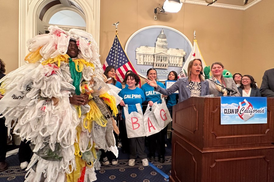 California Democratic state Sen. Catherine Blakespear gestures toward a person covered in plastic bags during a news conference at the Capitol in Sacramento, Calif., on Thursday, Feb. 8, 2024. Blakespear has authored a bill that would ban all plastic shopping bags in California. (AP/Adam Beam)