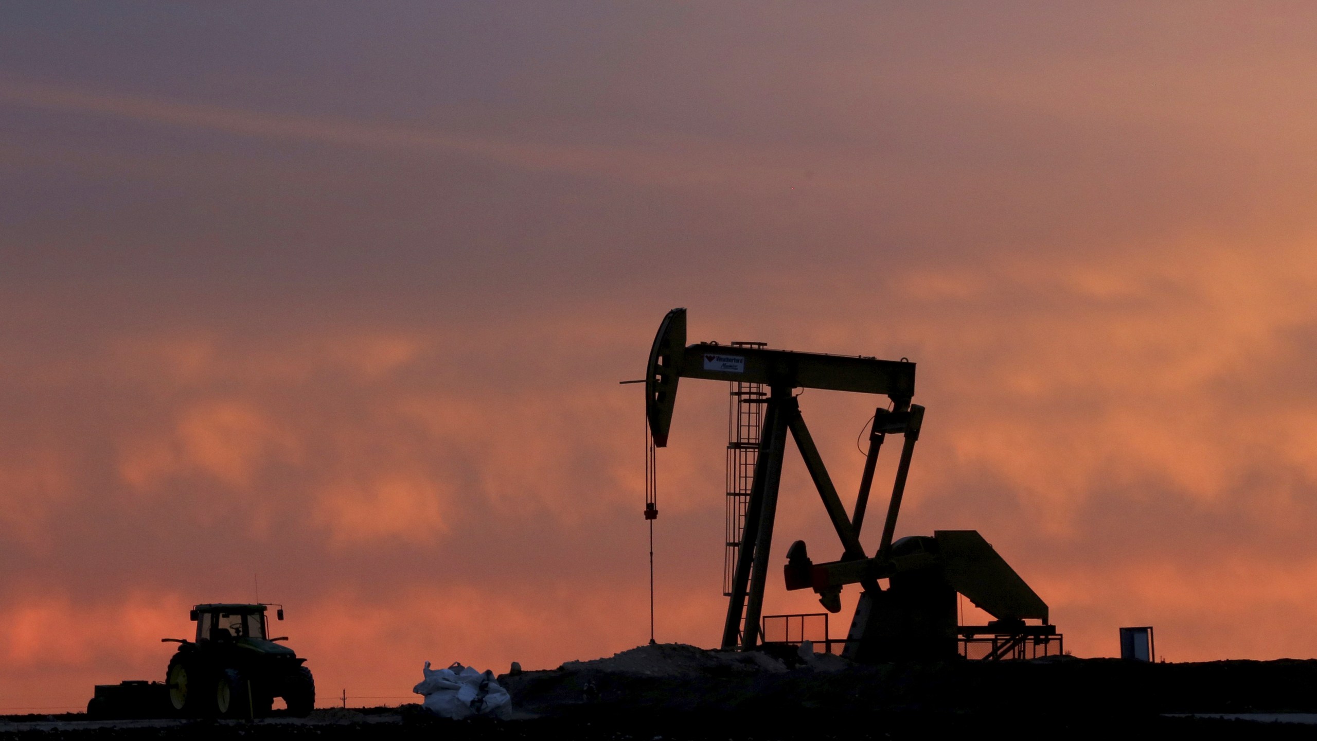 FILE - A well pump works at sunset on a farm near Sweetwater, Texas, on Dec. 22, 2014. Diamondback Energy will buy rival Endeavor Energy Resources in a cash-and-stock deal valued at about $26 billion to create a drilling giant in the Southwest United States. (AP Photo/LM Otero, File)