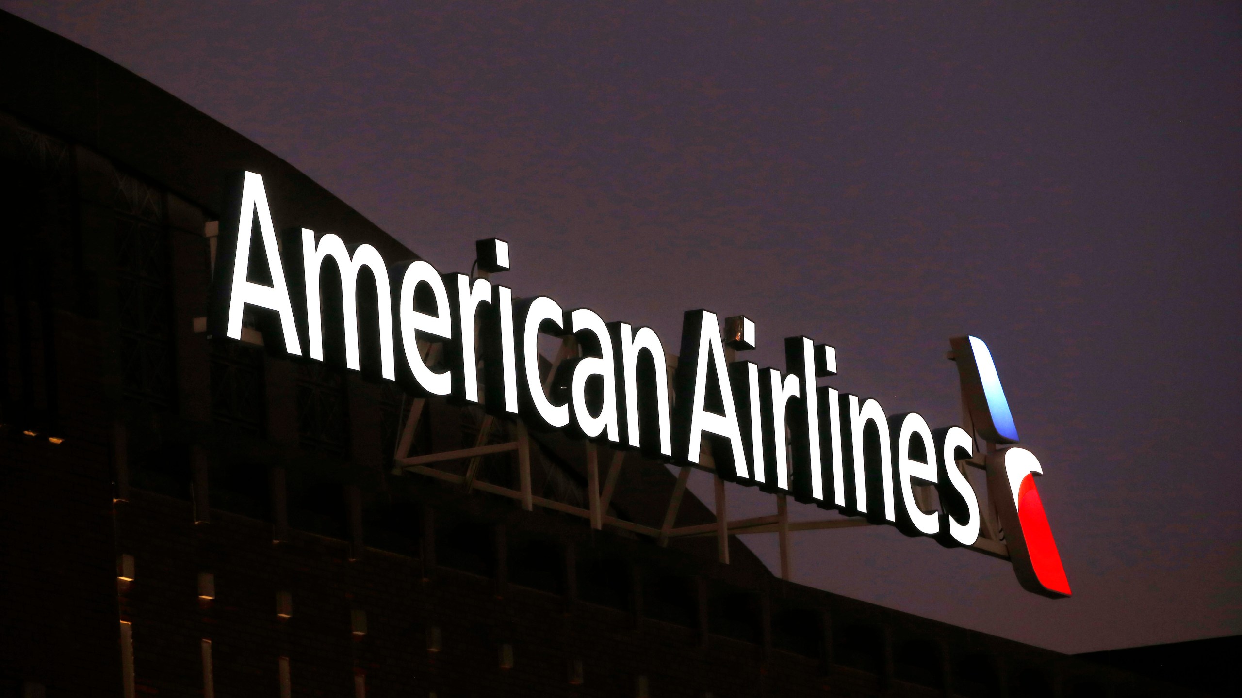FILE - The American Airlines logo is seen atop the American Airlines Center, Dec. 19, 2017, in Dallas. Federal safety officials said Monday, Feb. 12, 2024, that they are investigating an incident in which an American Airlines jet had a braking problem and ran off the end of the runway after landing at Dallas-Fort Worth International Airport. (AP Photo/Michael Ainsworth, File)
