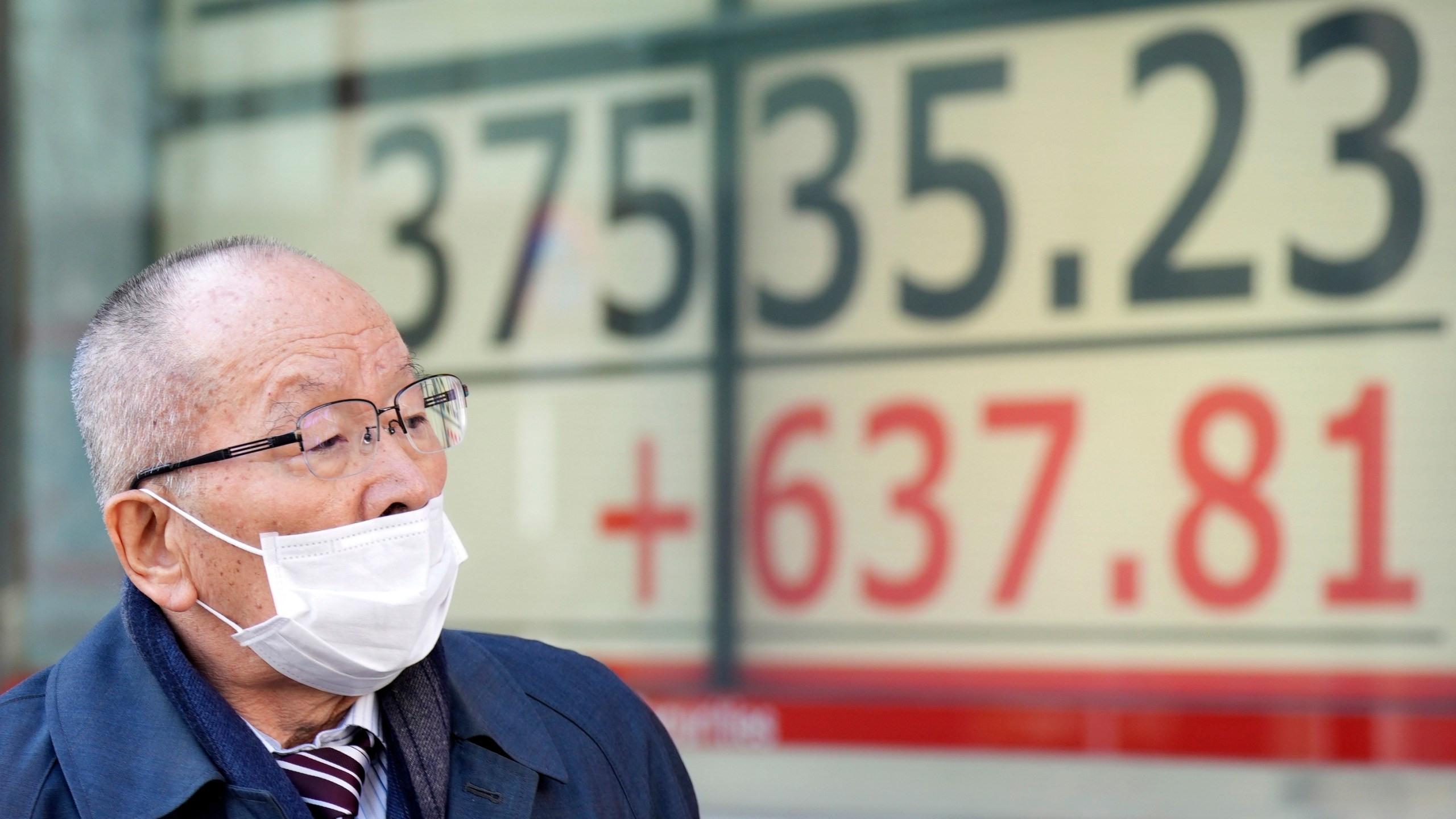 A person walks in front of an electronic stock board showing Japan's Nikkei 225 index at a securities firm Tuesday, Feb. 13, 2024, in Tokyo. Asian shares mostly rose Tuesday, as investors watched for the latest indicators on U.S. inflation. (AP Photo/Eugene Hoshiko)