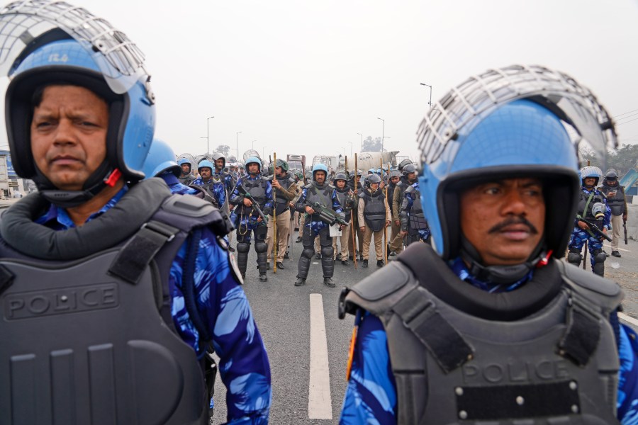 Rapid Action Force personnel guard a major highway at Singhu near New Delhi to stop thousands of protesting farmers from entering the capital, India, Tuesday, Feb.13, 2024. Farmers, who began their march from northern Haryana and Punjab states, are asking for a guaranteed minimum support price for all farm produce. (AP Photo/Manish Swarup)