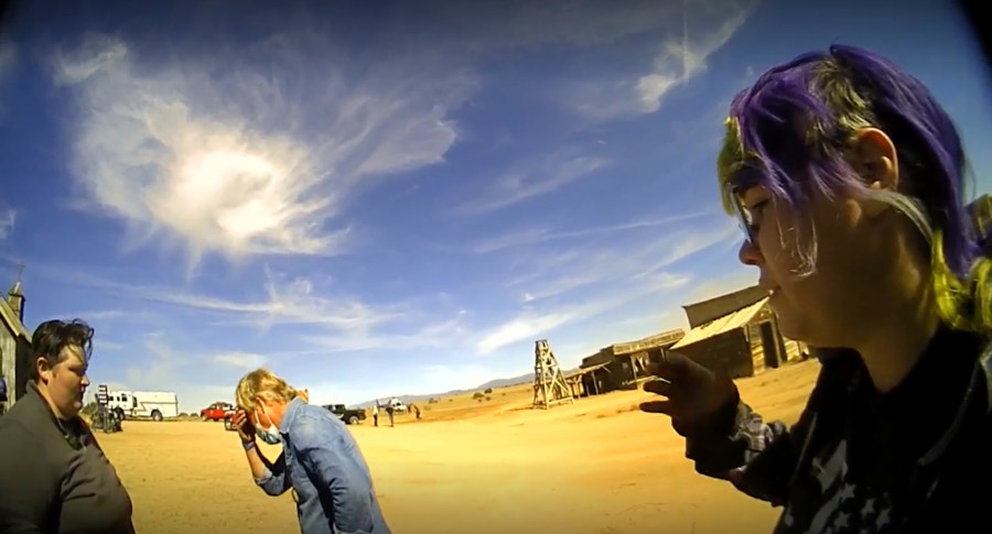 In this screen grab from lapel camera video provided by the Santa Fe County Sheriff's Office, movie set armorer Hannah Gutierrez-Reed, right, speaks with a sheriff's deputy as other colleagues, at center and left, react on the set of the western move "Rust," shortly after the fatal shooting of cinematographer Halyna Hutchins by Alec Baldwin during a rehearsal, Oct. 21, 2021, in New Mexico. The scheduled trial next week of the movie weapons supervisor in the fatal shooting of a cinematographer by Alec Baldwin may hinge on an enduring mystery: How did live ammunition find its way onto the set of a film set where it was expressly prohibited? (Santa Fe County Sheriff's Office via AP)