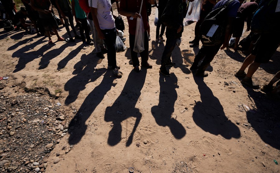 FILE - Migrants wait to be processed by the U.S. Customs and Border Patrol after they crossed the Rio Grande and entered the U.S. from Mexico, Oct. 19, 2023, in Eagle Pass, Texas. A federal judge on Thursday, Feb. 15, 2024, will consider whether Texas can enforce a new law that gives police broad authority to arrest migrants who are accused of entering the U.S. illegally and empowers local judges to order them out of the country. (AP Photo/Eric Gay, File)