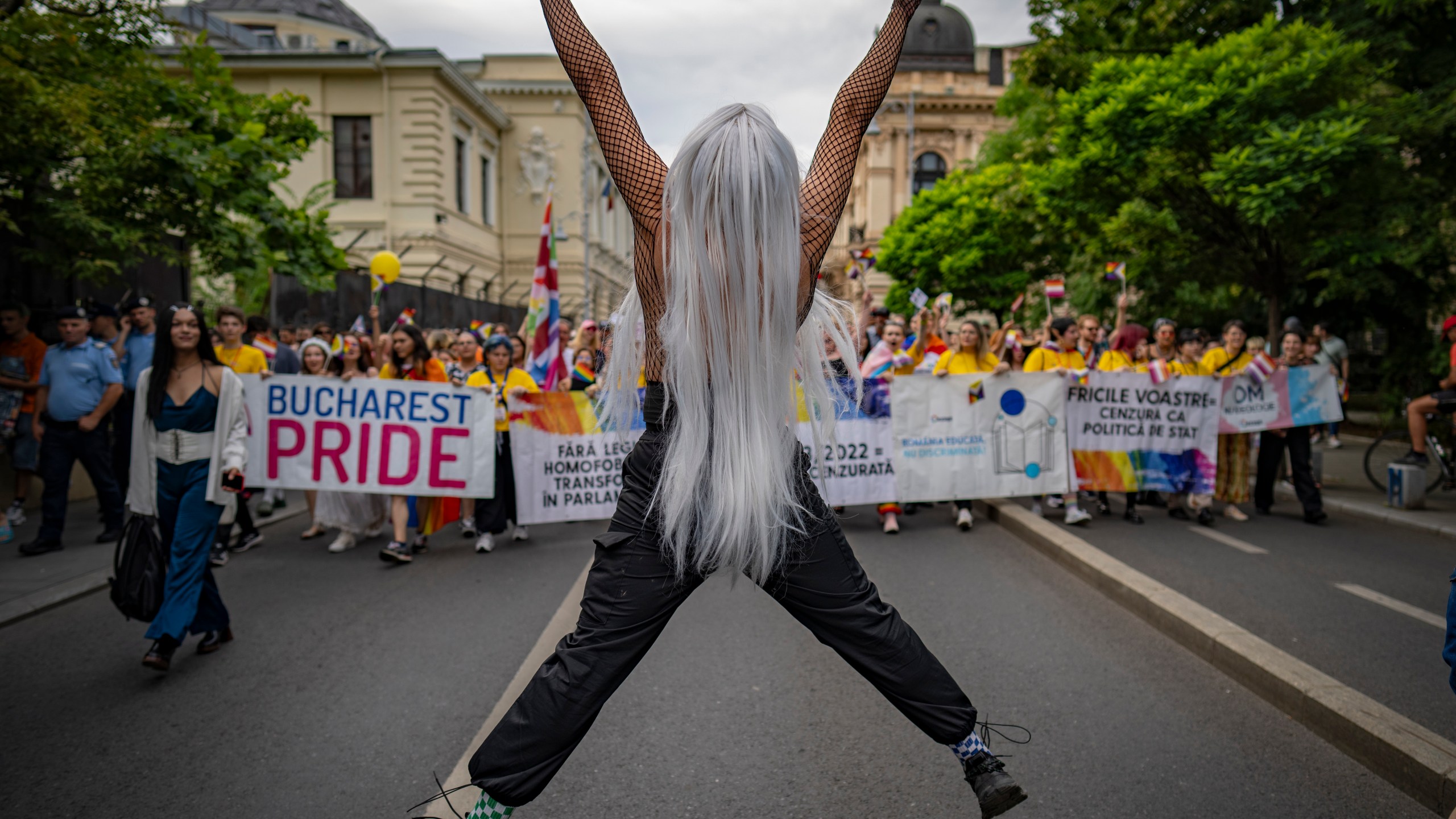 FILE - A participant jumps flashing victory signs during a pride parade in Bucharest, Romania, Saturday, July 29, 2023. Greece is becoming the first majority-Orthodox Christian nation to legalize same-sex marriage. At least for the near future, it will be the only one. The Eastern Orthodox leadership, despite lacking a single doctrinal authority like a pope, has been unanimous in opposing recognition of same-sex relationships. (AP Photo/Vadim Ghirda, File)