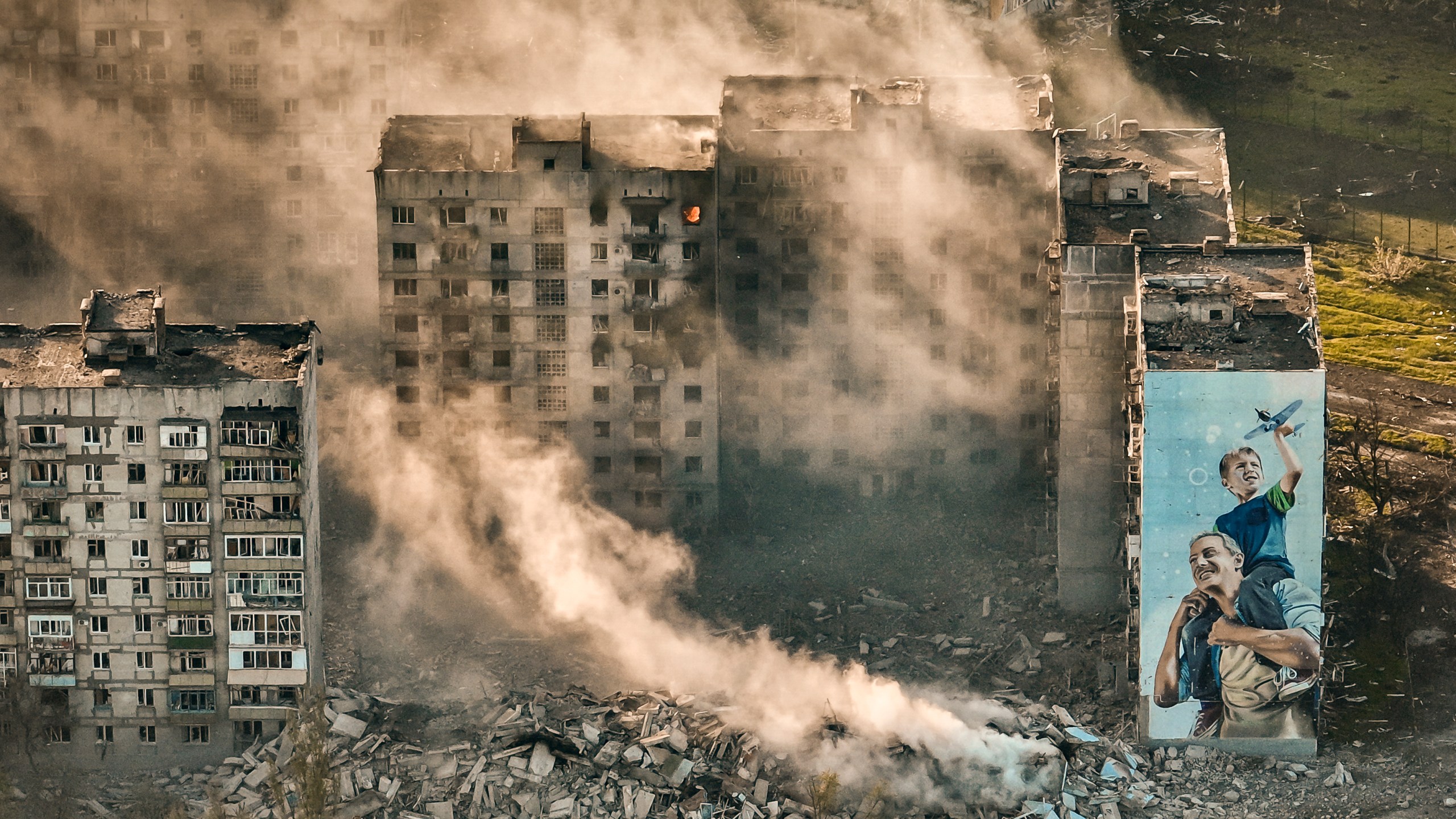 FILE - Smoke rises from a building in Bakhmut, site of the heaviest battles with the Russian troops in the Donetsk region, Ukraine, April 26, 2023. The GOP has been softening its stance on Russia ever since Donald Trump won the 2016 presidential election following Russian hacking of his Democratic opponents. The reasons include Russian President Vladimir Putin holding himself out as an international champion of conservative Christian values, the GOP's growing skepticism of international entanglements and Trump's own personal embrace of the Russian leader. Now the GOP's ambivalence on Russia has stalled additional aid to Ukraine. (AP Photo/Libkos, File)