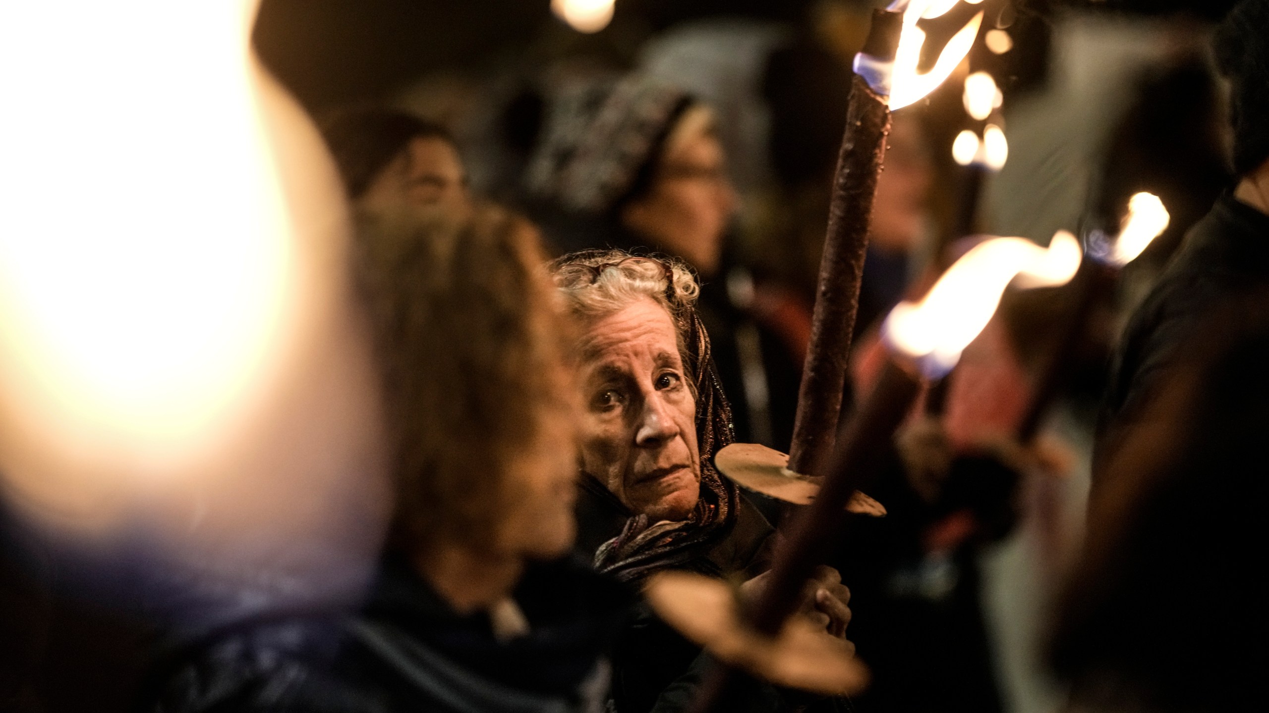 People hold torches as they demand the immediate release of the Israeli hostages held in the Gaza Strip by the Hamas militant group, in Jerusalem, Monday, Feb. 19, 2024. (AP Photo/Leo Correa)