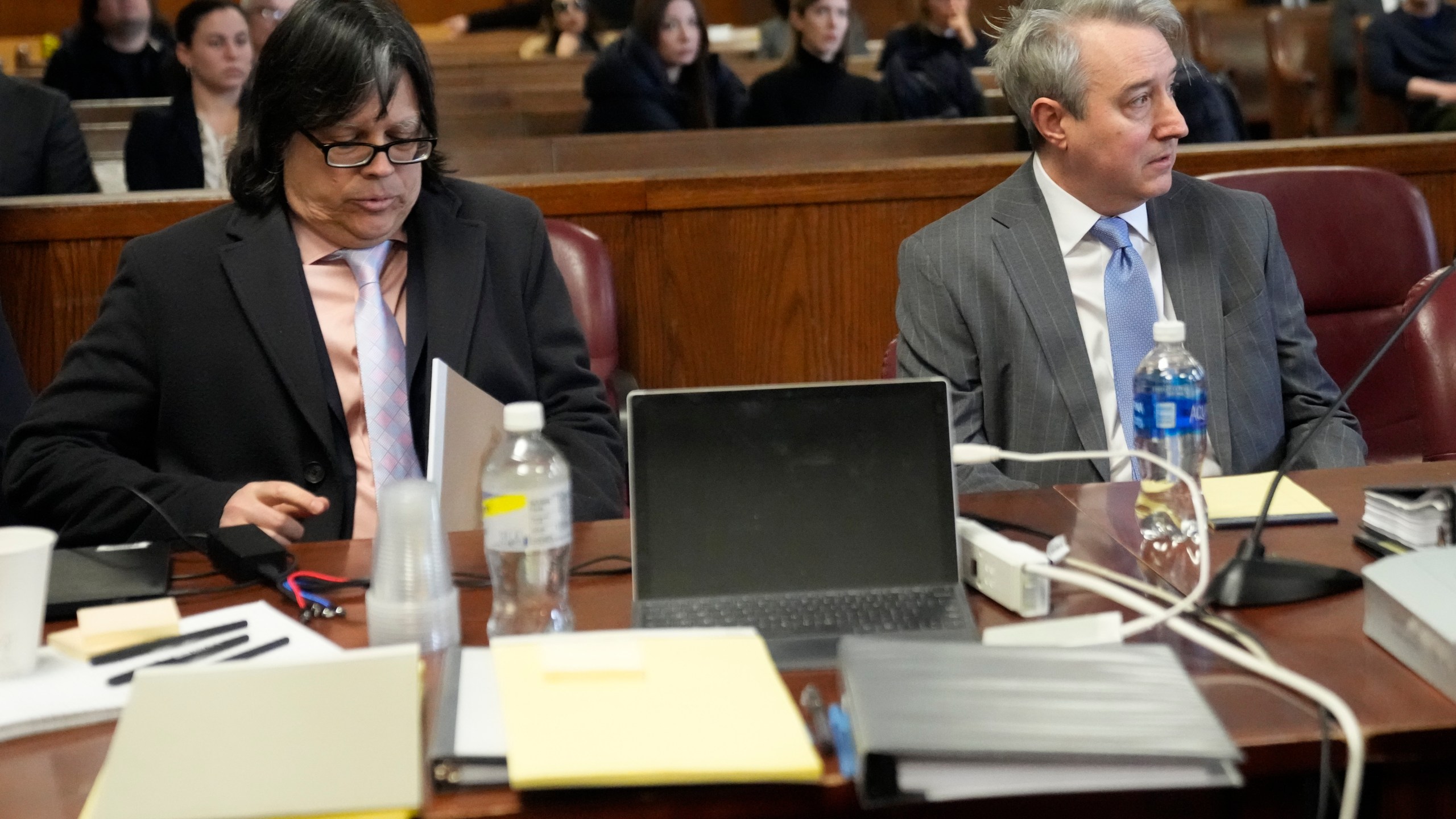 Memorabilia seller Edward Kosinski, left, and former Rock & Roll Hall of Fame curator Craig Inciardi are seated in the defendants chair in the supreme court, Wednesday, Feb. 21, 2024, in New York. A criminal case involving handwritten lyrics to the classic rock megahit “Hotel California” and other Eagles favorites went to trial Wednesday in New York, with three men accused of scheming to thwart band co-founder Don Henley’s efforts to reclaim the allegedly ill-gotten documents. (AP Photo/Mary Altaffer)