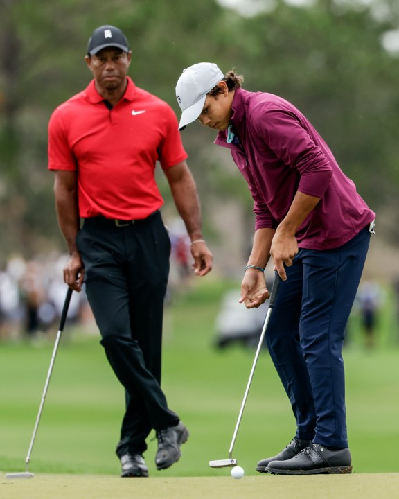 FILE -Tiger Woods, left, watches his son Charlie, right, putt ball during the final round of the PNC Championship golf tournament Sunday, Dec. 17, 2023, in Orlando, Fla. Charlie Woods, 15, will be playing a pre-qualifier on Thursday in Hobe Sound, Fla., the first step before a full qualifier for the Cognizant Classic on the PGA Tour. (AP Photo/Kevin Kolczynski, File)