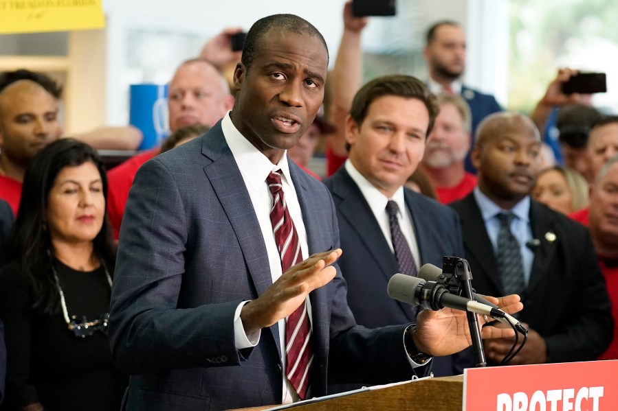 FILE - Florida Surgeon General Dr. Joseph Ladapo gestures as speaks to supporters and members of the media before a bill signing by Gov. Ron DeSantis Thursday, Nov. 18, 2021, in Brandon, Fla. Florida's controversial surgeon general is drawing criticism for his handling of an elementary school's measles outbreak, telling parents of unvaccinated children it is their choice whether their student attends class — a direct contravention of federal guidelines. (AP Photo/Chris O'Meara, File)