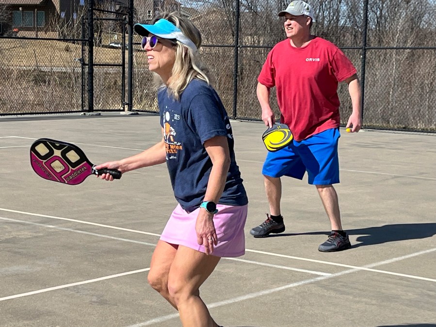 Stacy Lawson, left, and her husband, Hugh Lawson, play a game of pickleball on an outdoor court in Omaha, Neb., Sunday, Feb. 25, 2024. Temperatures usually hover around freezing this time of year. (AP Photo/Margery Beck)