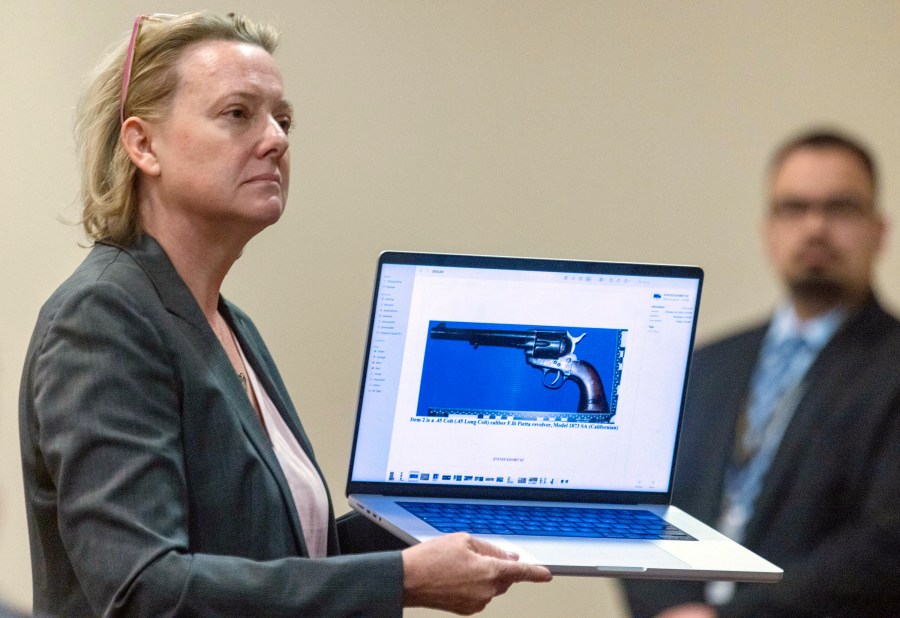 CORRECTION: REMOVES REFERENCE ABOUT OWNERSHIP OF GUN - Special prosecutor Kari Morrissey shows defense attorney Jason Bowles a picture of a firearmReed during Hannah Gutierrez-Reed trial at District Court, Monday, Feb. 26, 2024, in Santa Fe, N.M. Gutierrez-Reed is charged with involuntary manslaughter and tampering with evidence in the October 2021 death of cinematographer Halyna Hutchins during the filming of the Western “Rust”. (Luis Sánchez Saturno/Santa Fe New Mexican via AP, Pool)