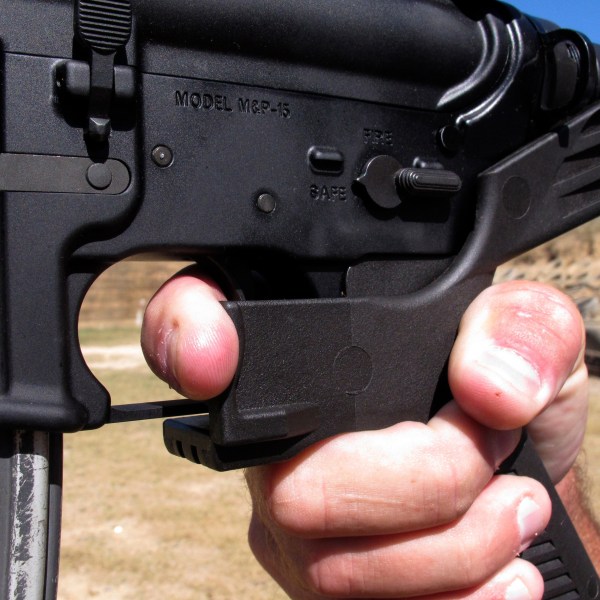 FILE - Shooting instructor Frankie McRae demonstrates the grip on an AR-15 rifle fitted with a "bump stock" at his 37 PSR Gun Club in Bunnlevel, N.C., on Oct. 4, 2017. Gun accessories known as bump stocks hit the market more than a decade ago. The U.S. government initially concluded that the devices that make semi-automatic weapons fire faster didn't violate a federal ban on machine guns. That changed after a gunman with bump stock-equipped rifles killed 60 people and wounded hundreds in Las Vegas in 2017. (AP Photo/Allen G. Breed, File)