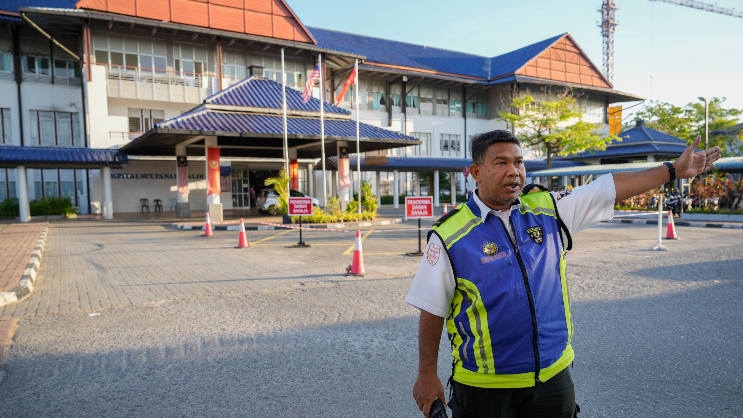Security personal chase media out from Sultanah Maliha Hospital, where Norway's King Harald believed has been admitted with an infection, on the Malaysian resort island of Langkawi, Malaysia, Thursday, Feb. 29, 2024. Malaysian national news agency Bernama cited unidentified sources as confirming that Europe's oldest monarch was warded at the hospital's Royal Suite. (AP Photo/Vincent Thian)