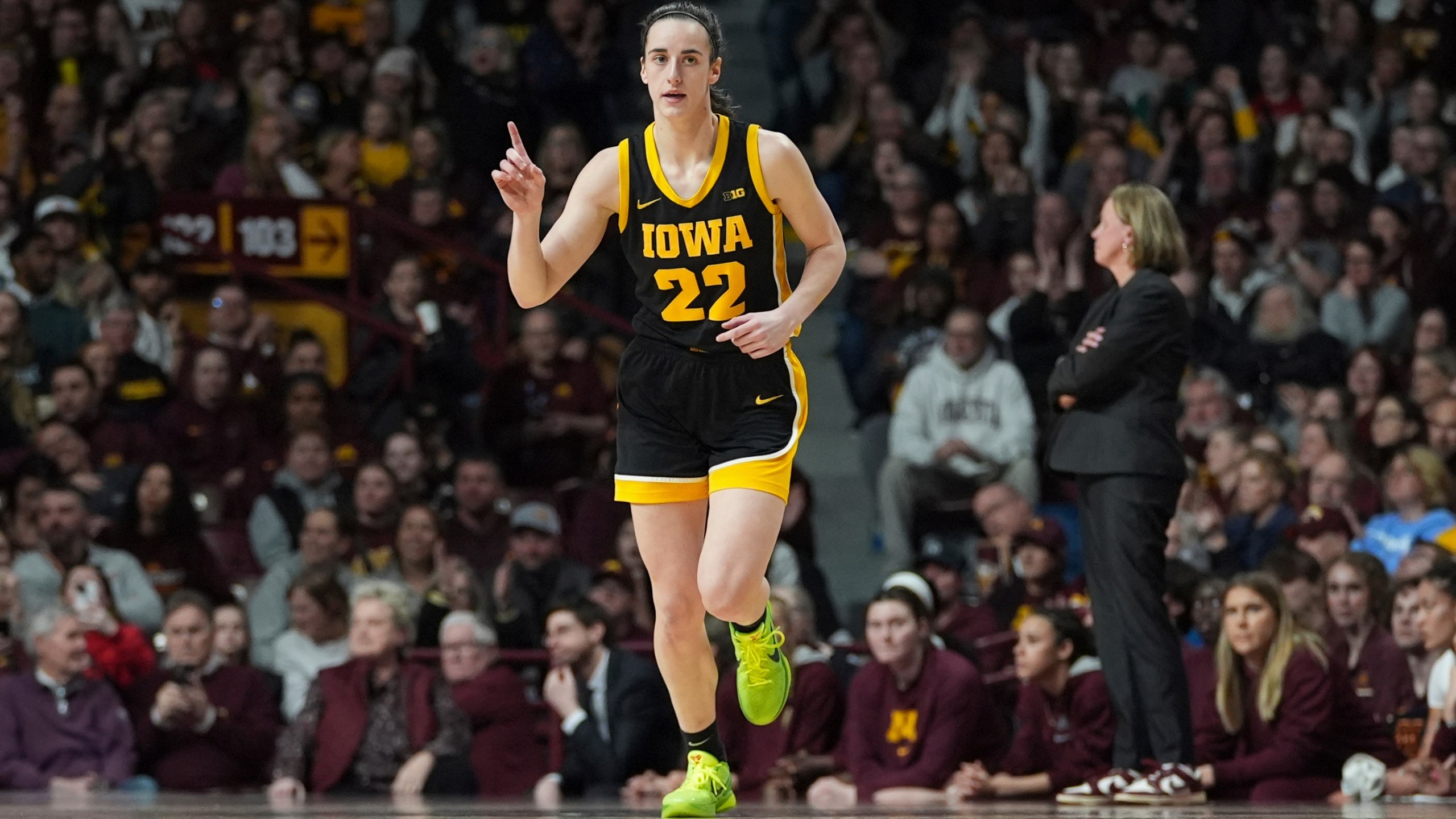 Iowa guard Caitlin Clark (22) points after an Iowa basket scored during the first half of an NCAA college basketball game against Minnesota, Wednesday, Feb. 28, 2024, in Minneapolis. (AP Photo/Abbie Parr)