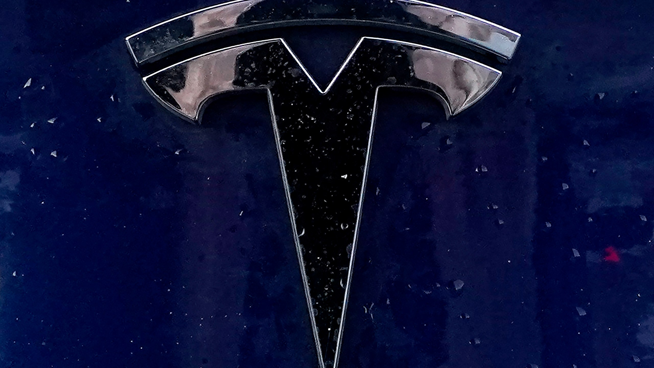 FILE - A Tesla electric vehicle emblem is affixed to a passenger vehicle Sunday, Feb. 21, 2021, in Boston. The lawyers who successfully argued that a massive pay package for Tesla CEO Elon Musk was illegal and should be voided have asked the presiding judge to award them company stock worth $5.6 billion as legal fees. The attorneys, who represented Tesla shareholders in the case decided in January, made the request of the Delaware judge in court papers filed Friday, March 1, 2024. (AP Photo/Steven Senne)