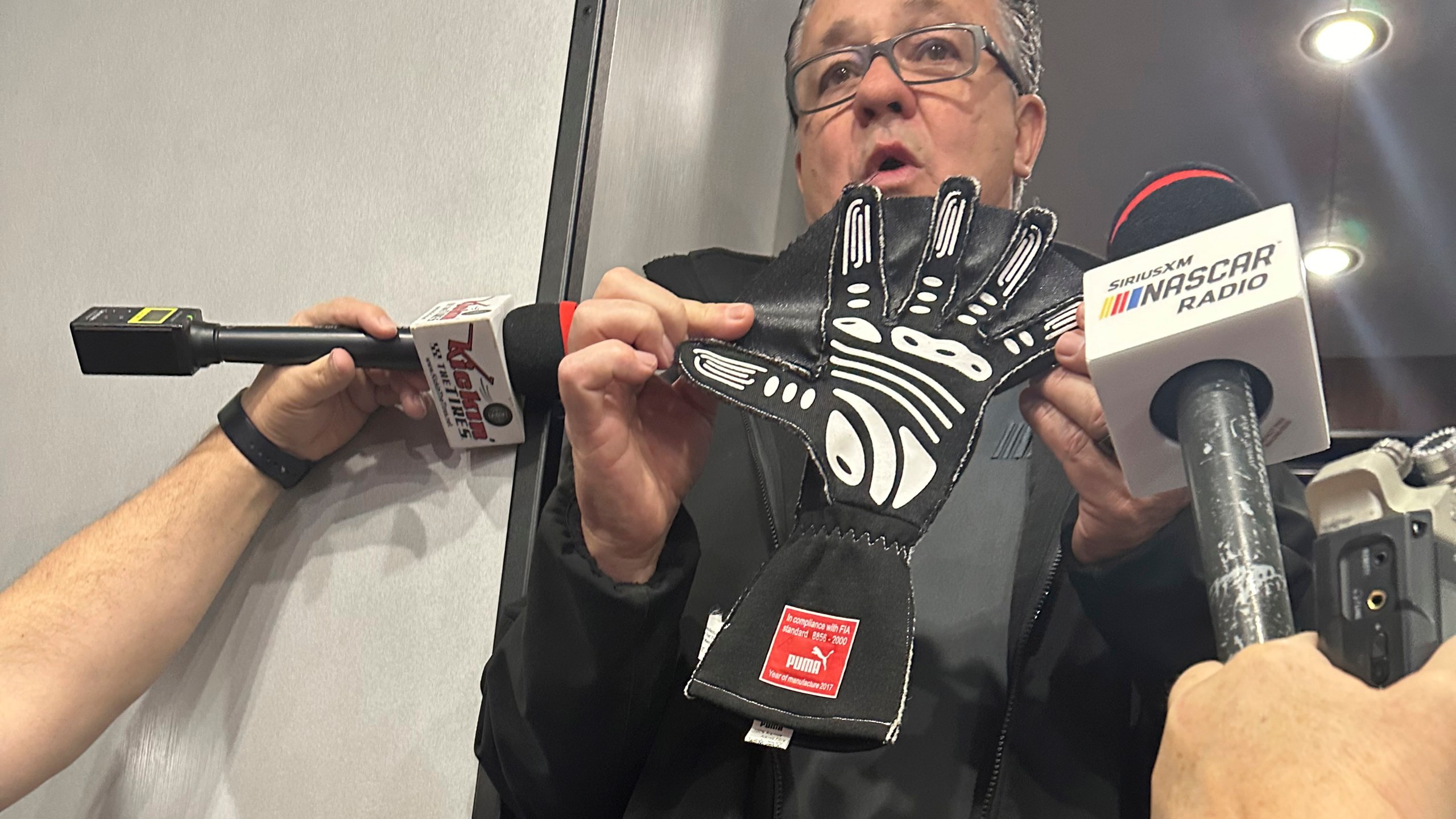 NASCAR Cup Series Managing Director Brad Moran shows reporters, Saturday, March 2, 2024, at Las Vegas Motor Speedway, the illegal glove Joey Logano of Team Penske was caught wearing during qualifying last week at Atlanta Motor Speedway. The webbing between the fingers that give the glove a “Spider-Man” appearance are used to block air when a driver puts his hand out the window during qualifying. (AP Photo/Jenna Fryer)