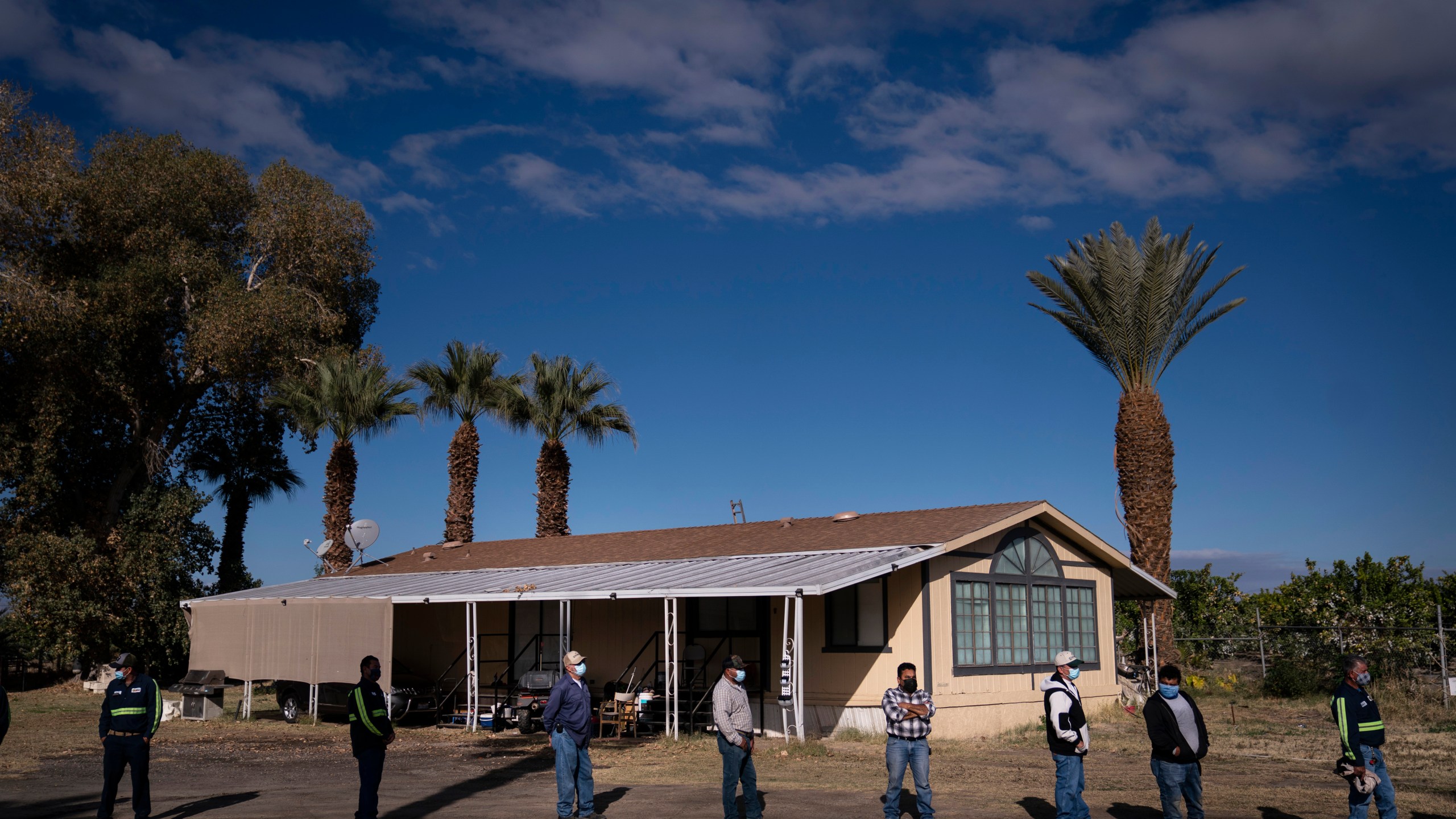 FILE - Farm workers wait in line at Tudor Ranch in Mecca, Calif., Jan. 21, 2021. Every year, heat kills more people than floods, hurricanes and tornadoes combined, and experts warn that extreme heat will become more intense, frequent and lethal with climate change. (AP Photo/Jae C. Hong, File)