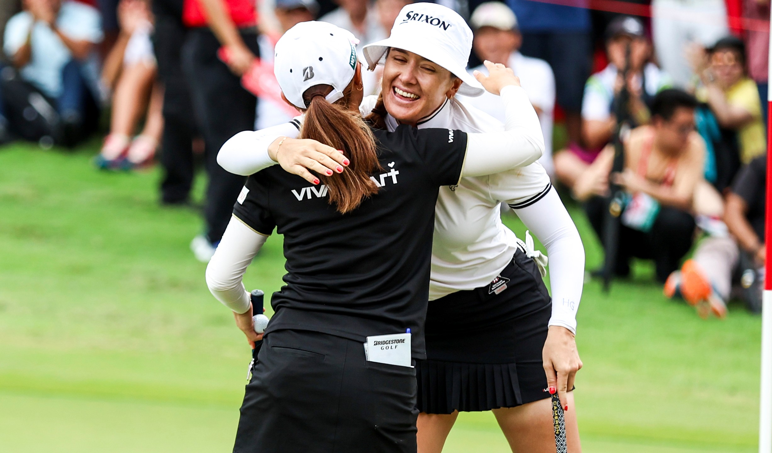 Hannah Green of Australia, right, and Ayaka Furoe of Japan embraces after completing the 18th hole of the final round of the HSBC Women's Wold Championship at the Sentosa Golf Club in Singapore Sunday, March 3, 2024. (AP Photo/Danial Hakim)