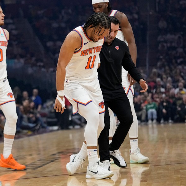 New York Knicks guard Jalen Brunson (11) is helped off the court after an injury in the first half of an NBA basketball game against the Cleveland Cavaliers, Sunday, March 3, 2024, in Cleveland. (AP Photo/Sue Ogrocki)