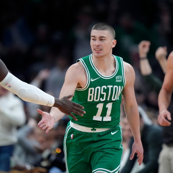 Boston Celtics guard Payton Pritchard, center, celebrates with guard Jrue Holiday, left, in front of Golden State Warriors guard Klay Thompson, right, after scoring in the first half of an NBA basketball game, Sunday, March 3, 2024, in Boston. (AP Photo/Steven Senne)