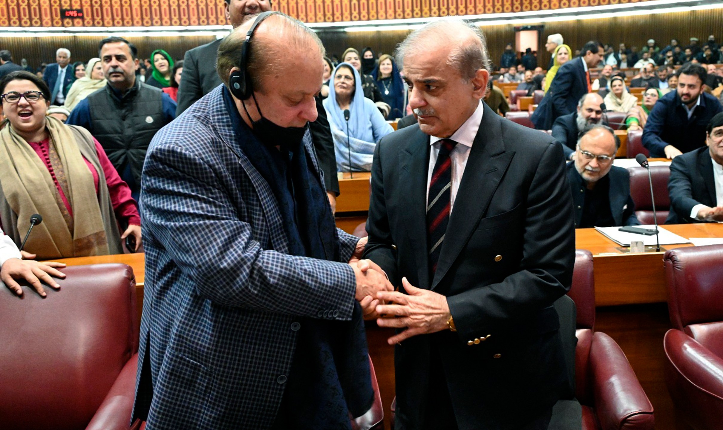 In this photo released by the National Assembly office, Pakistan's newly elected Prime Minister Shehbaz Sharif, foreground right, is congratulated by his elder brother and former Prime Minister Nawaz Sharif following his appointment, at a parliament session, in Islamabad, Pakistan, Sunday, March 3, 2024. Lawmakers in Pakistan's National Assembly elected Sunday Shehbaz Sharif as the country's new prime minister for the second time as allies of imprisoned former premier Imran Khan in parliament shouted in protest, alleging rigging in last month's election. (National Assembly Office via AP)