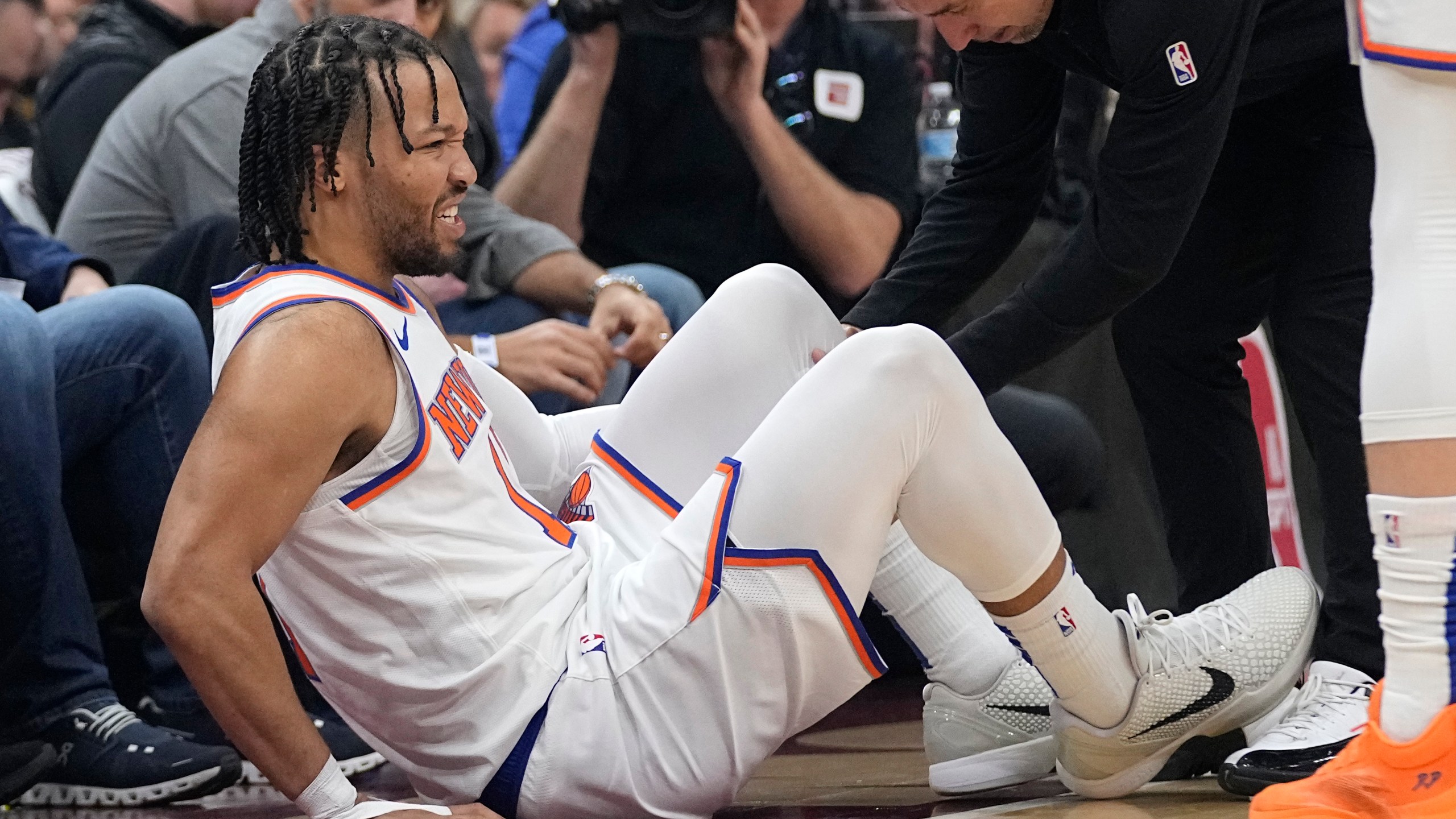 New York Knicks guard Jalen Brunson (11) is tended to after an injury in the first half of an NBA basketball game against the Cleveland Cavaliers, Sunday, March 3, 2024, in Cleveland. (AP Photo/Sue Ogrocki)