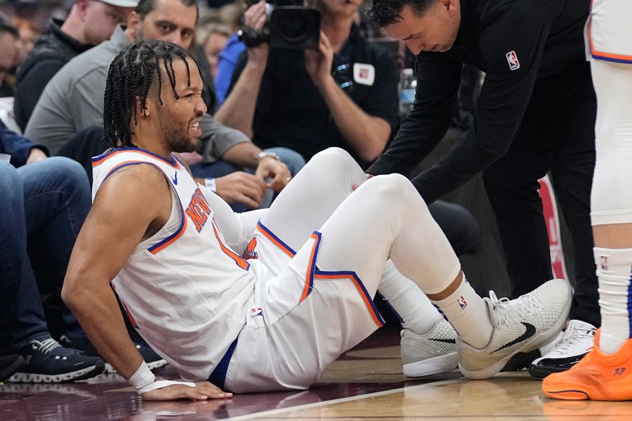 New York Knicks guard Jalen Brunson (11) is tended to after an injury in the first half of an NBA basketball game against the Cleveland Cavaliers, Sunday, March 3, 2024, in Cleveland. (AP Photo/Sue Ogrocki)