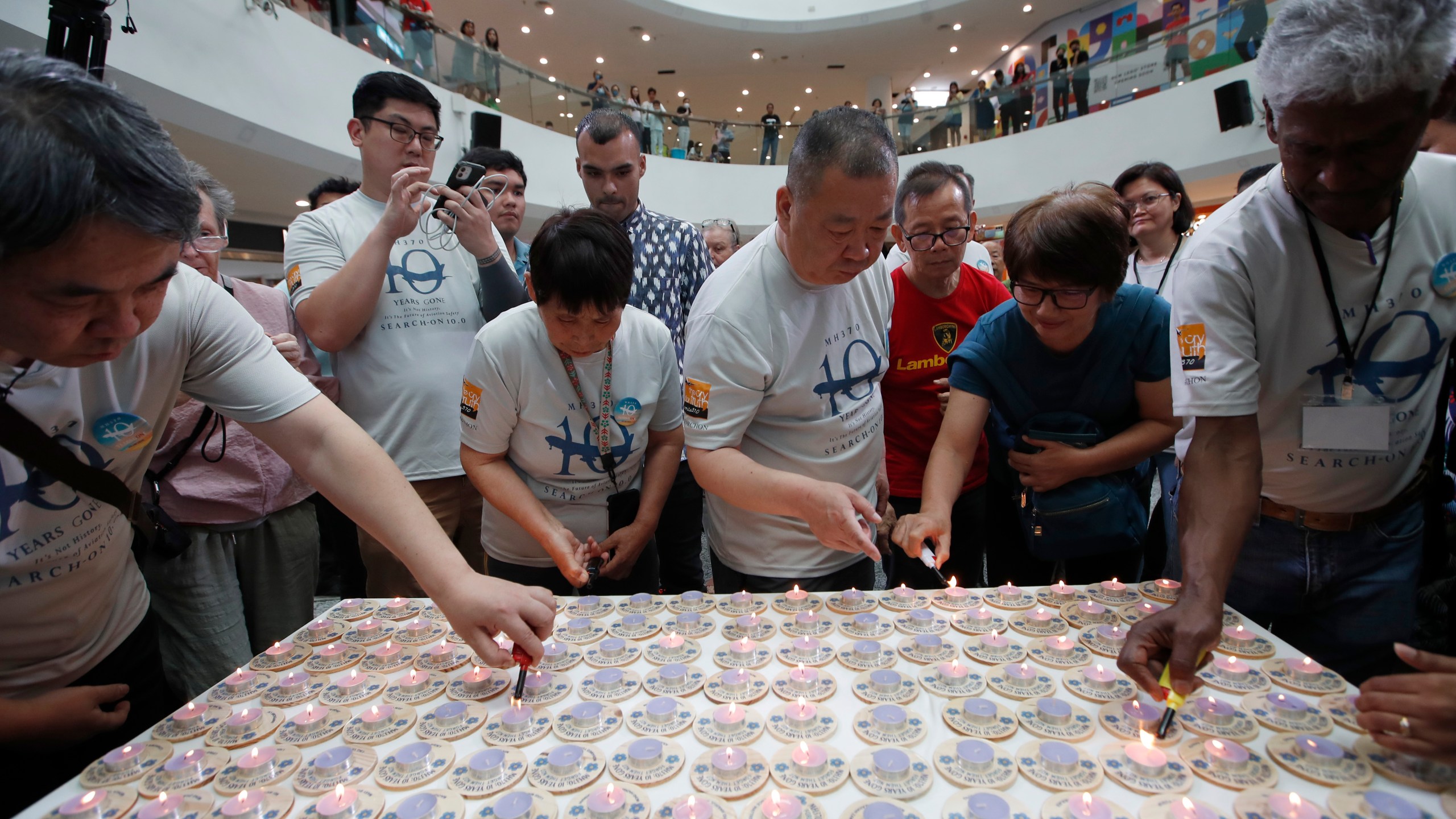 Family members and relatives of passengers on board of the missing Malaysia Airlines Flight 370 light candles during the tenth annual remembrance event at a shopping mall, in Subang Jaya, on the outskirts of Kuala Lumpur, Malaysia, Sunday, March 3, 2024. Ten years ago, a Malaysia Airlines Flight 370, had disappeared March 8, 2014 while en route from Kuala Lumpur to Beijing with over 200 people on board. (AP Photo/FL Wong)