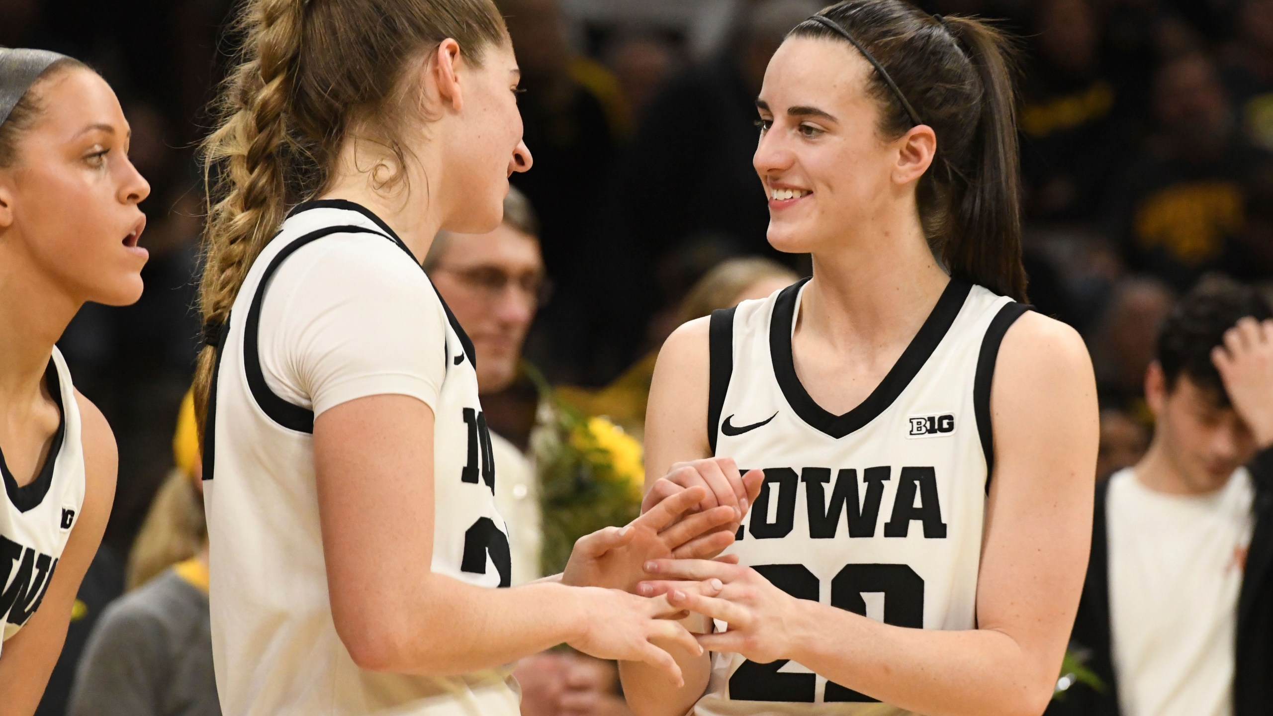 Iowa guards Kate Martin, second from left, greets Iowa guard Caitlin Clark (22) after they were introduced during Senior Day ceremonies following their victory over Ohio State in an NCAA college basketball game, Sunday, March 3, 2024, in Iowa City, Iowa. (AP Photo/Cliff Jette)