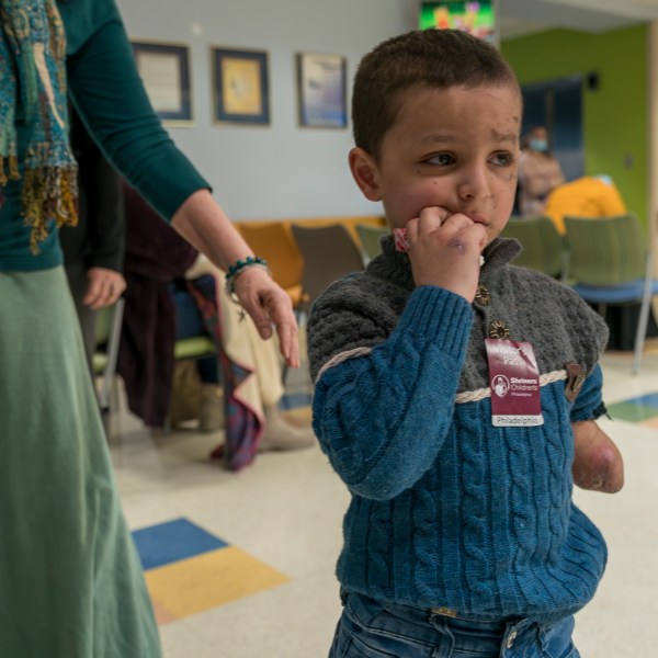 Four-year-old Omar Abu Kuwaik, from Gaza, stands in a waiting room at Shriners Children's Hospital, Thursday, Jan. 18, 2024, in Philadelphia. On Dec. 6, 2023 two Israeli airstrikes slammed into Omar's grandparents' home in the Nuseirat refugee camp, in central Gaza. The explosion peeled the skin from his face, exposing raw pink layers peppered with deep lacerations. His left arm could not be saved below the elbow. His parents, 6-year-old sister, grandparents, two aunts and a cousin were killed. (AP Photo/Peter K. Afriyie)