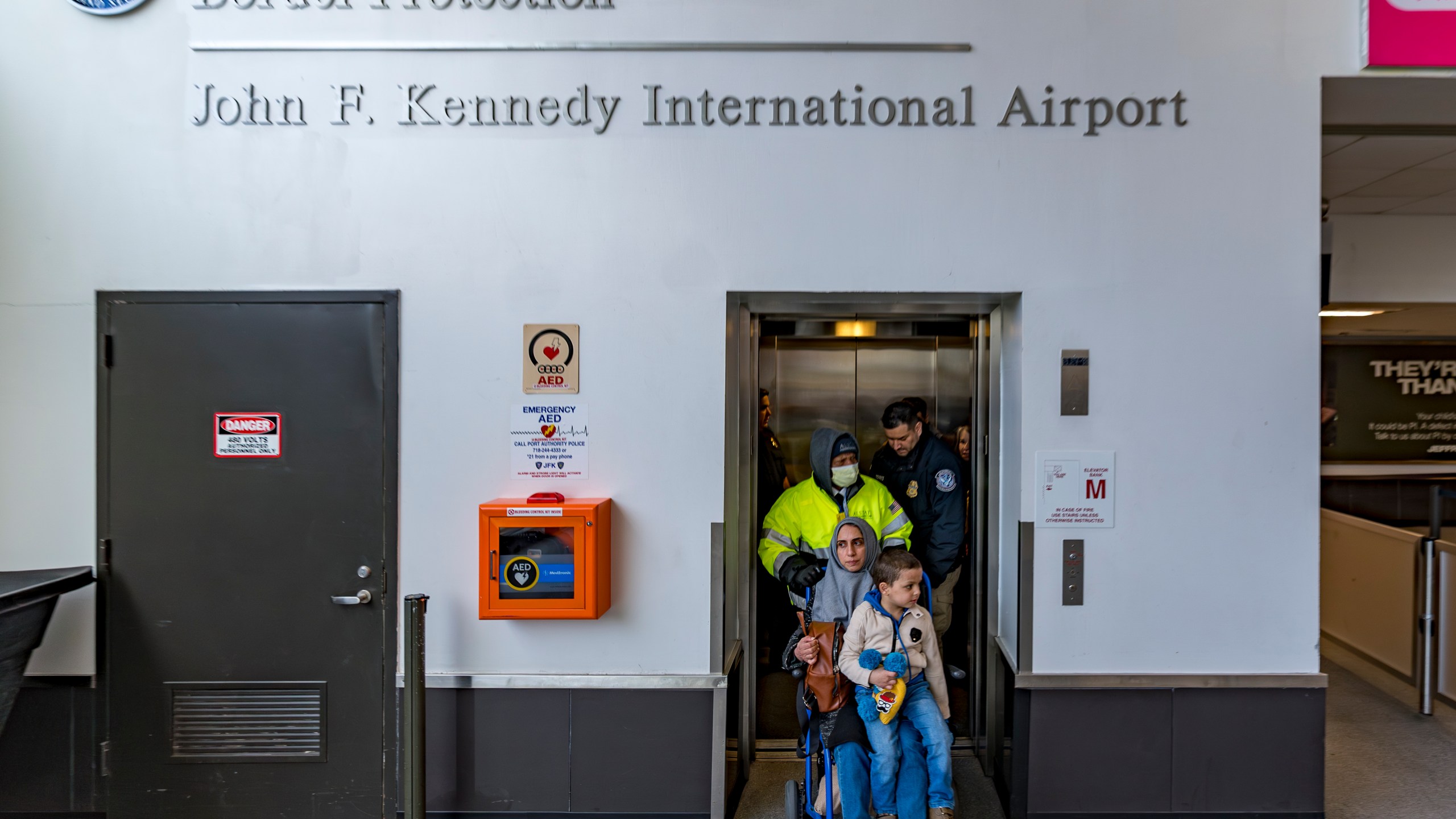 Four-year-old Omar Abu Kuwaik, and his aunt Maha Abu Kuwaik, both from Gaza, are escorted through John F. Kennedy International Airport after departing a flight from Egypt on Wednesday, Jan. 17, 2024, in New York. (AP Photo/Peter K. Afriyie)