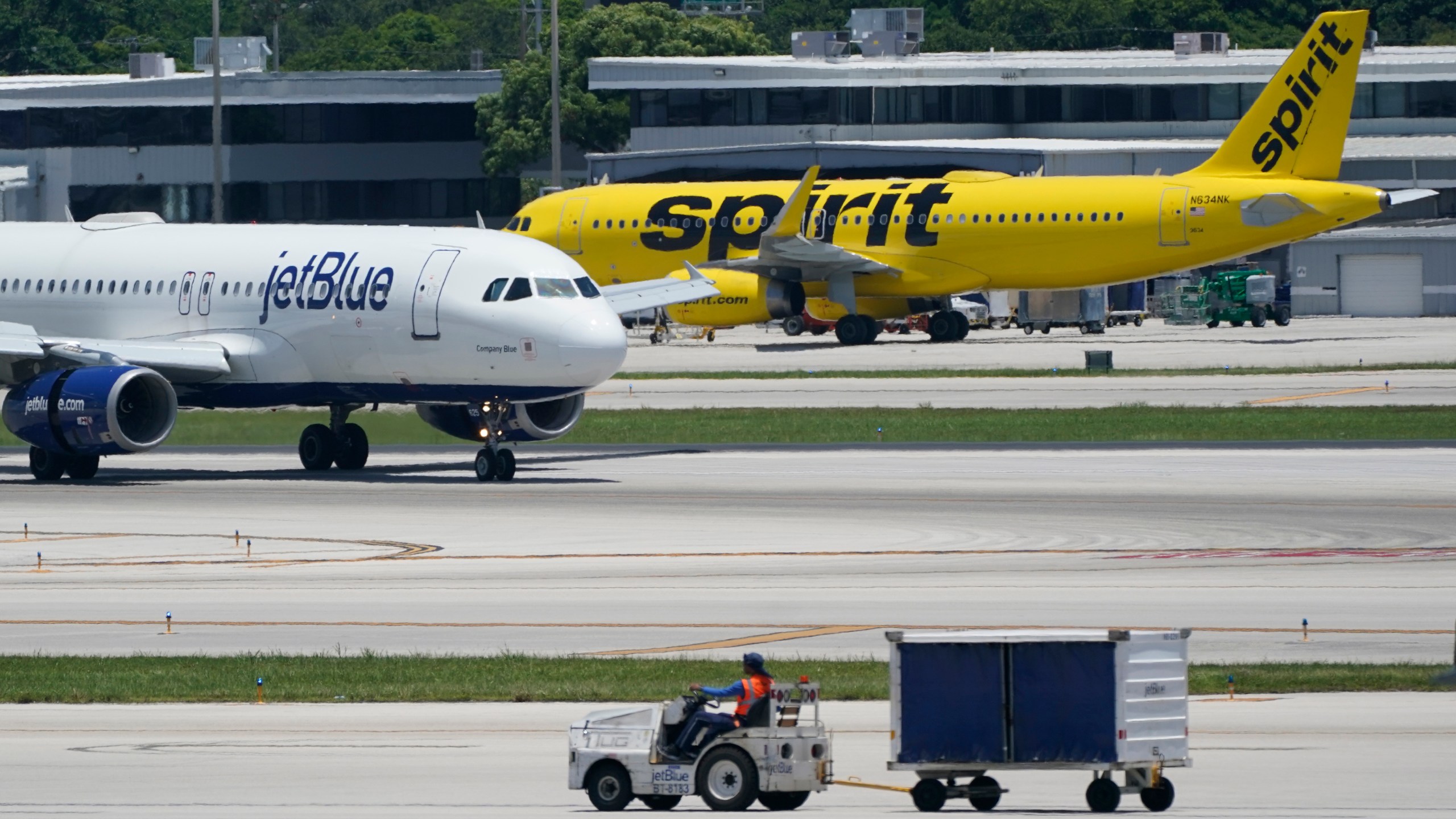 FILE - A JetBlue Airways Airbus A320, left, passes a Spirit Airlines Airbus A320 as it taxis on the runway, July 7, 2022, at the Fort Lauderdale-Hollywood International Airport in Fort Lauderdale, Fla. JetBlue and Spirit Airlines are ending their proposed $3.8 billion combination after a court ruling blocked their merger. JetBlue said Monday, March 4, 2024 that even though both companies still believe in the benefits of a combination, they felt they were unlikely to meet the required closing conditions before the July 24 deadline and mutually agreed that terminating the deal was the best decision for both. (AP Photo/Wilfredo Lee, File)