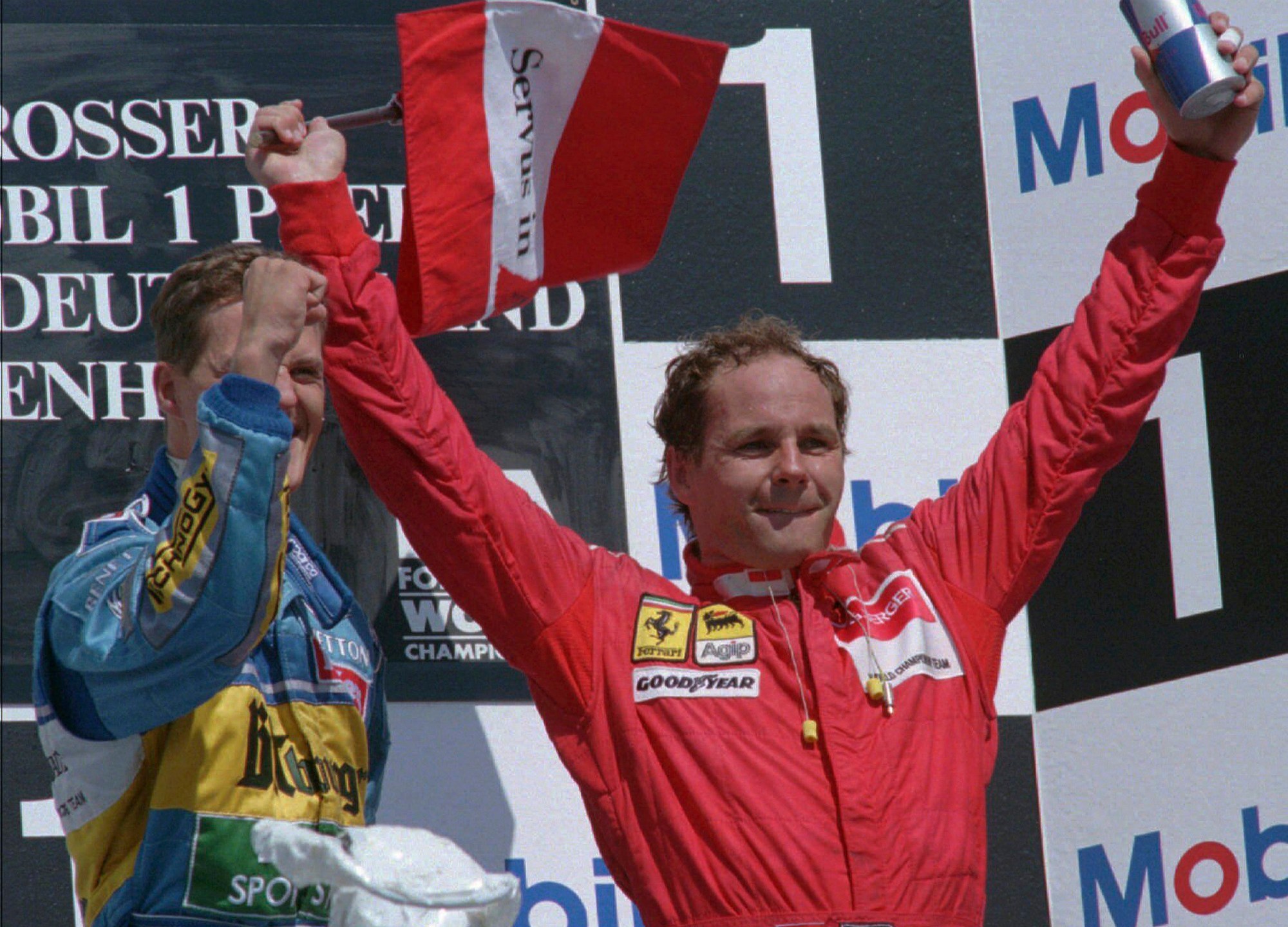 FILE - Michael Schumacher, the German winner of the German F1 Grand Prix, left, celebrates on the podium with third-placed Gerhard Berger of Austria, waving his national flag in Hockenheim, Germany, Sunday July 30, 1995. British police said Monday, March 4, 2024, that they have recovered a Ferrari stolen from Formula One driver Gerhard Berger in Italy almost three decades ago. The red Ferrari F512M was one of two sports cars taken while their drivers were in Imola, Italy for the San Marino Grand Prix in April 1995.(AP Photo/Roland Weihrauch, File)