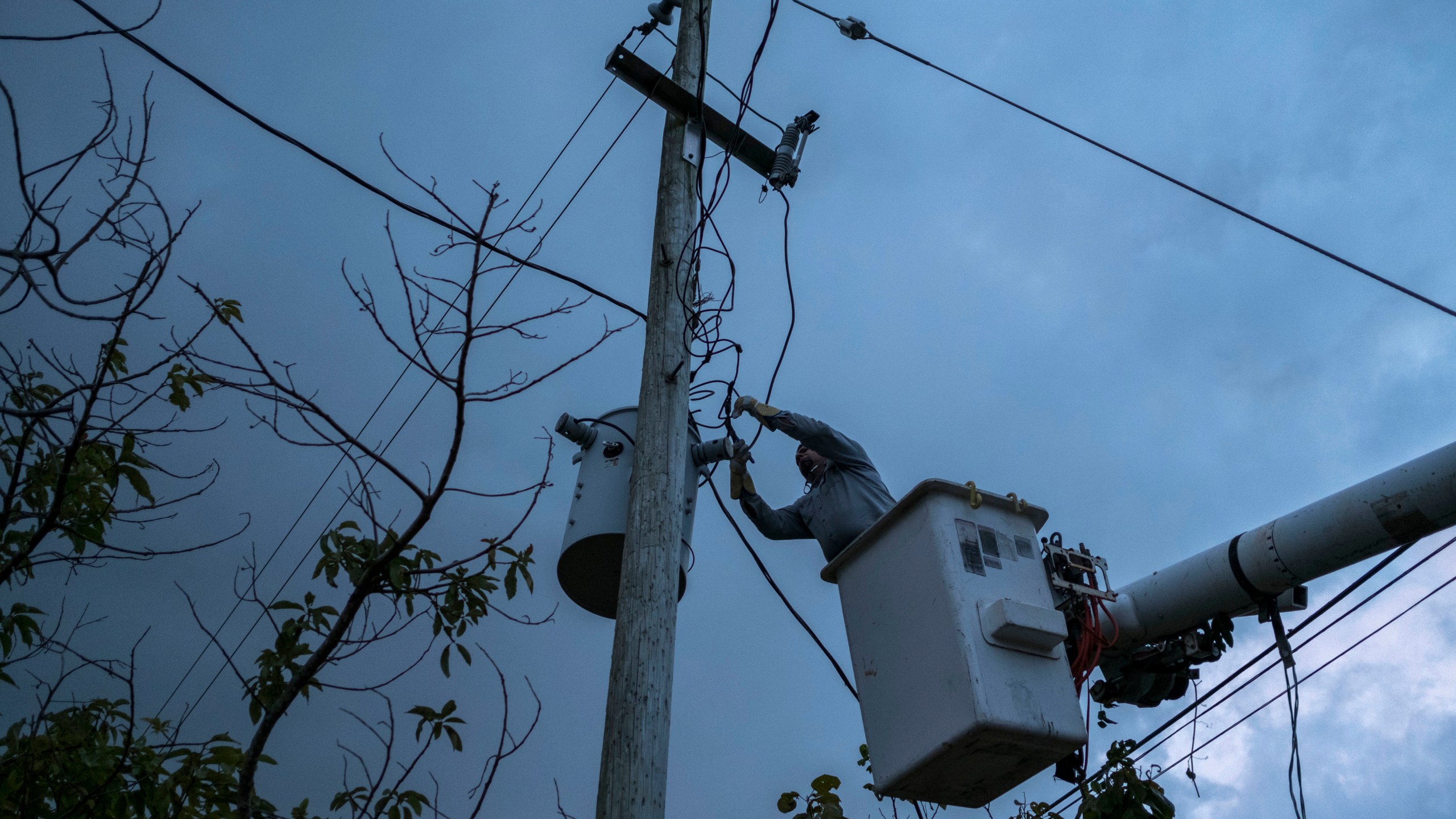 FILE - A worker from the Puerto Rico Power Authority works to restore power in Adjuntas, Puerto Rico, July 12, 2018. A key hearing over the future of Puerto Rico’s crumbling power company and its $9 billion debt began on March 4, 2024, in federal court following years of talks between the U.S. territory's government and creditors seeking to recover their investments. (AP Photo/Dennis M. Rivera Pichardo, File)