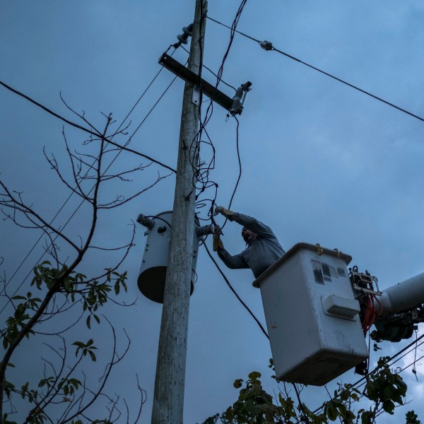 FILE - A worker from the Puerto Rico Power Authority works to restore power in Adjuntas, Puerto Rico, July 12, 2018. A key hearing over the future of Puerto Rico’s crumbling power company and its $9 billion debt began on March 4, 2024, in federal court following years of talks between the U.S. territory's government and creditors seeking to recover their investments. (AP Photo/Dennis M. Rivera Pichardo, File)