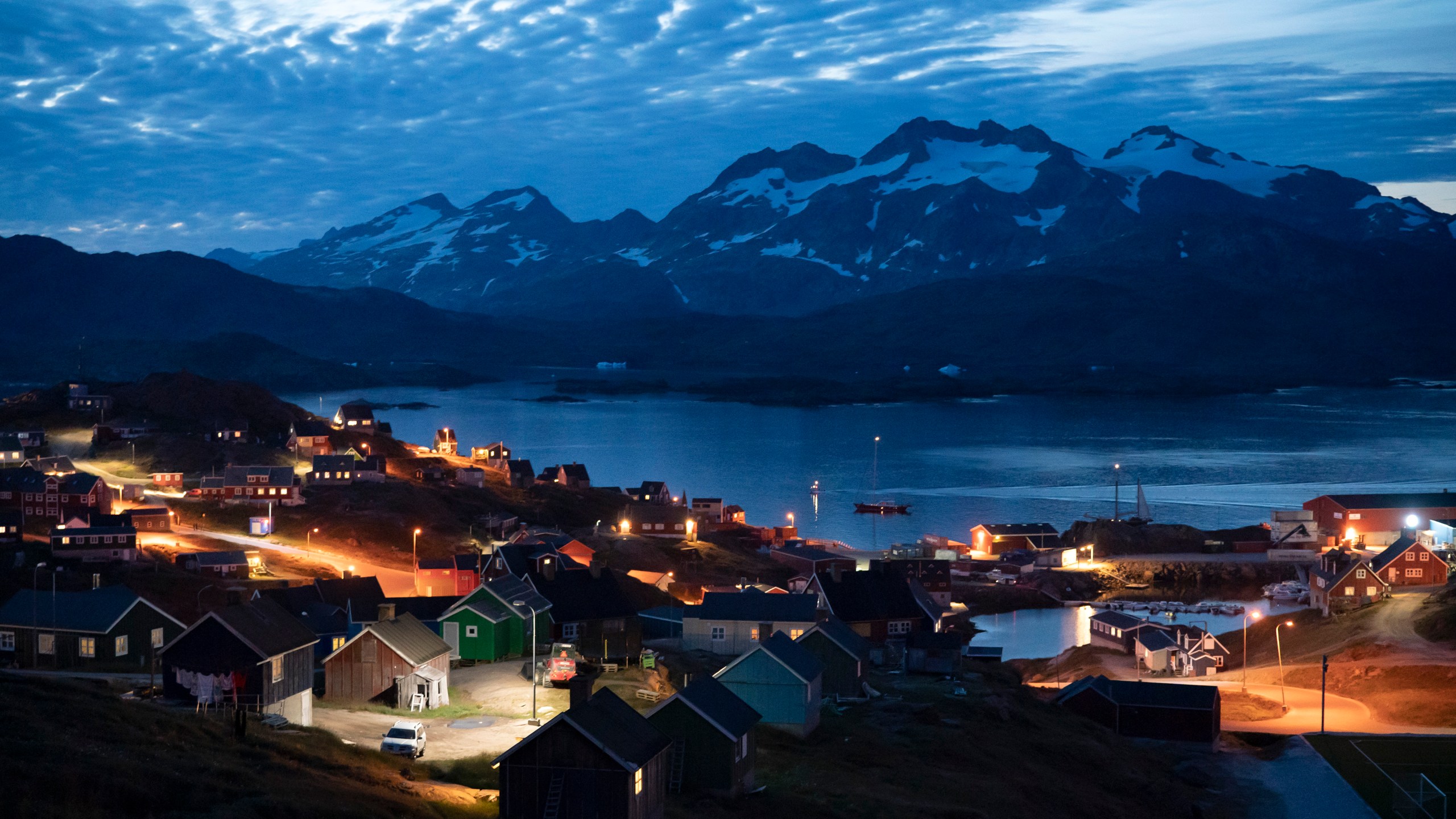 FILE - Homes are illuminated after the sunset in Tasiilaq, Greenland, Friday Aug. 16, 2019. A group of 143 Greenlandic women have sued the Danish state for having been fitted with coils in the 1960s and 1970s, and demand a total compensation of nearly 43 million kroner ($6.3 million), Danish broadcaster DR reported Monday, March 4, 2024.(AP Photo/Felipe Dana, File)