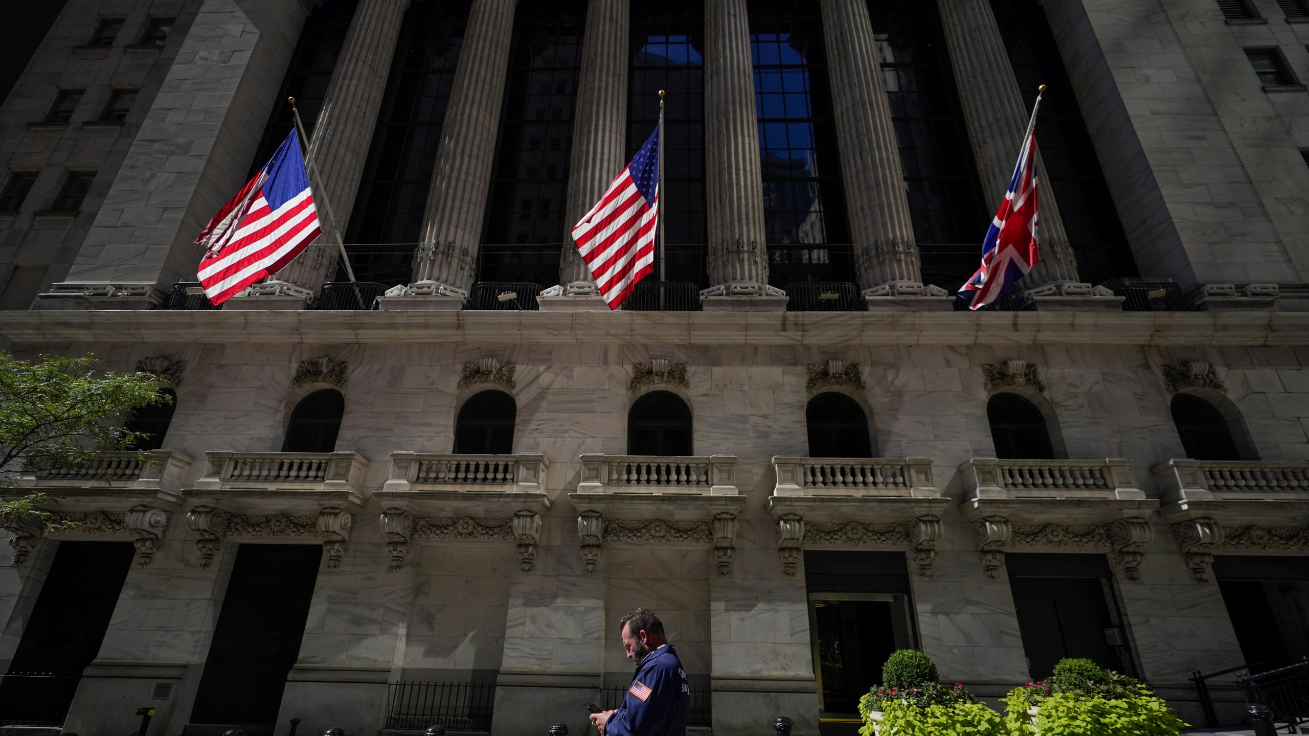 FILE - A trader looks over his cell phone outside the New York Stock Exchange, Wednesday, Sept. 14, 2022, in the financial district of Manhattan in New York. (AP Photo/Mary Altaffer, File)