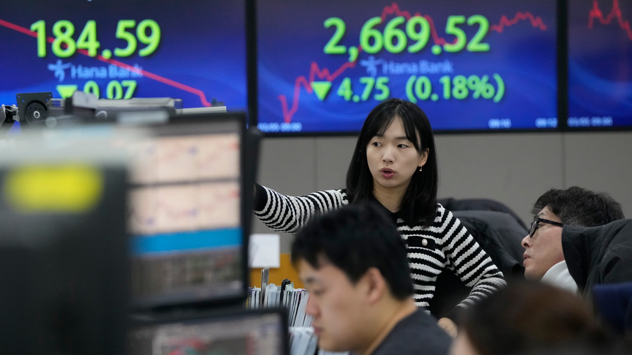 Currency traders watch monitors at the foreign exchange dealing room of the KEB Hana Bank headquarters in Seoul, South Korea, Tuesday, March 5, 2024. Shares were mixed Tuesday in Asia after China’s premier said the country’s target for economic growth this year is around 5%, in line with expectations. (AP Photo/Ahn Young-joon)