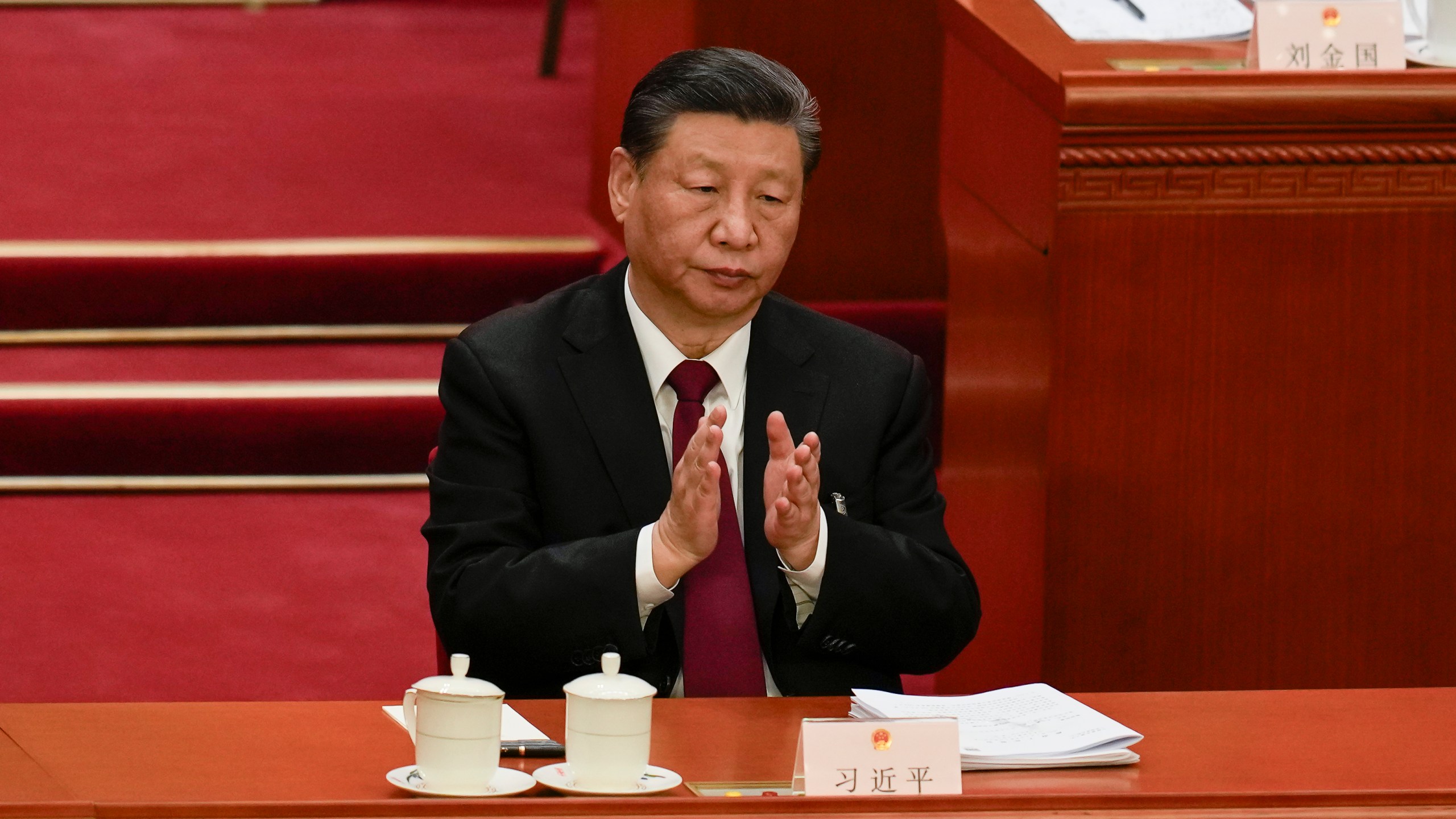 Chinese President Xi Jinping applauds during the opening session of the National People's Congress (NPC) at the Great Hall of the People in Beijing, China, Tuesday, March 5, 2024. (AP Photo/Ng Han Guan)