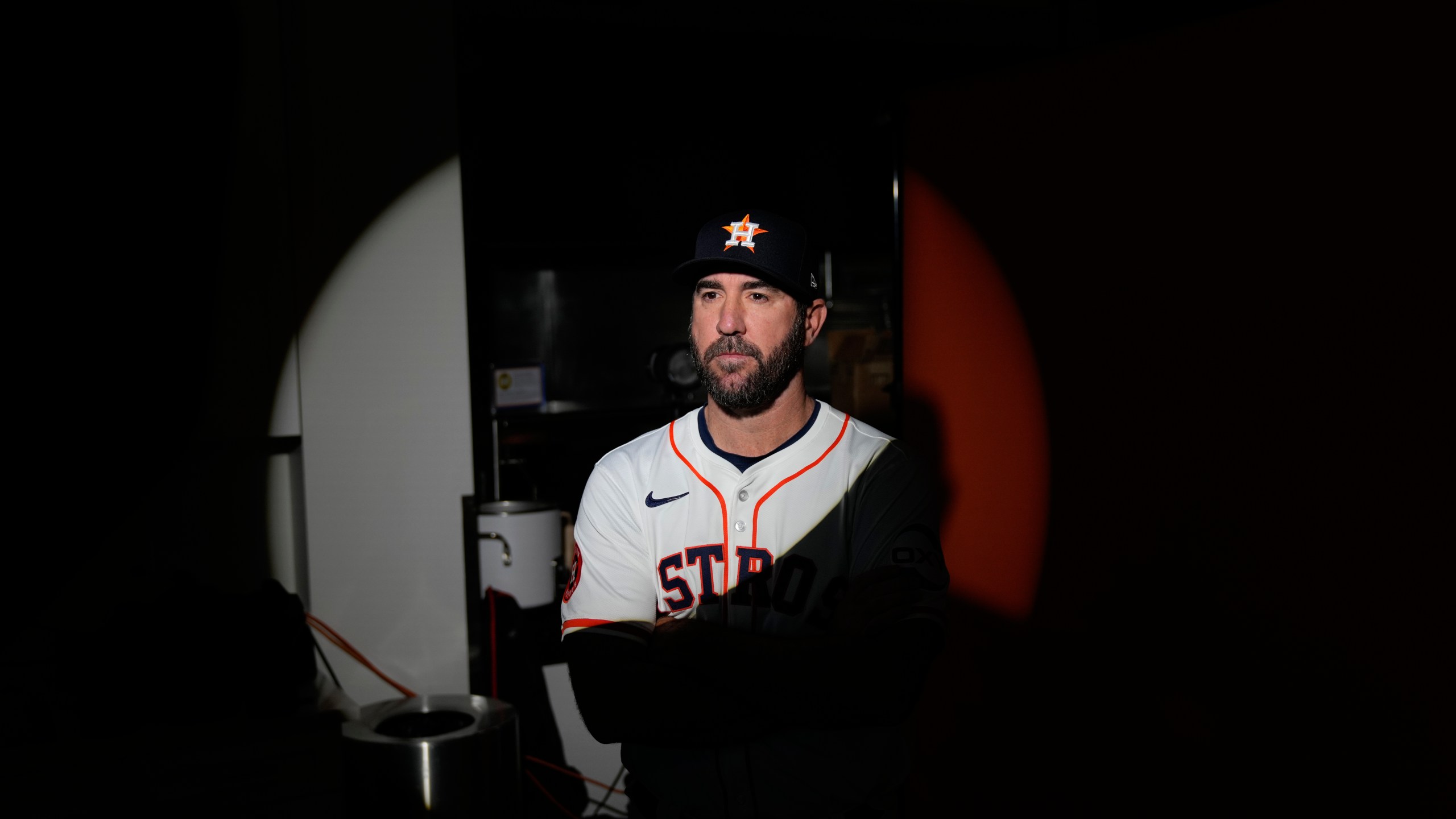 Pitcher Justin Verlander of the Houston Astros baseball team stands in a circle of light as he poses for a photographer during the team's media day, Wednesday, Feb. 21, 2024, in West Palm Beach, Fla. (AP Photo/Rebecca Blackwell)