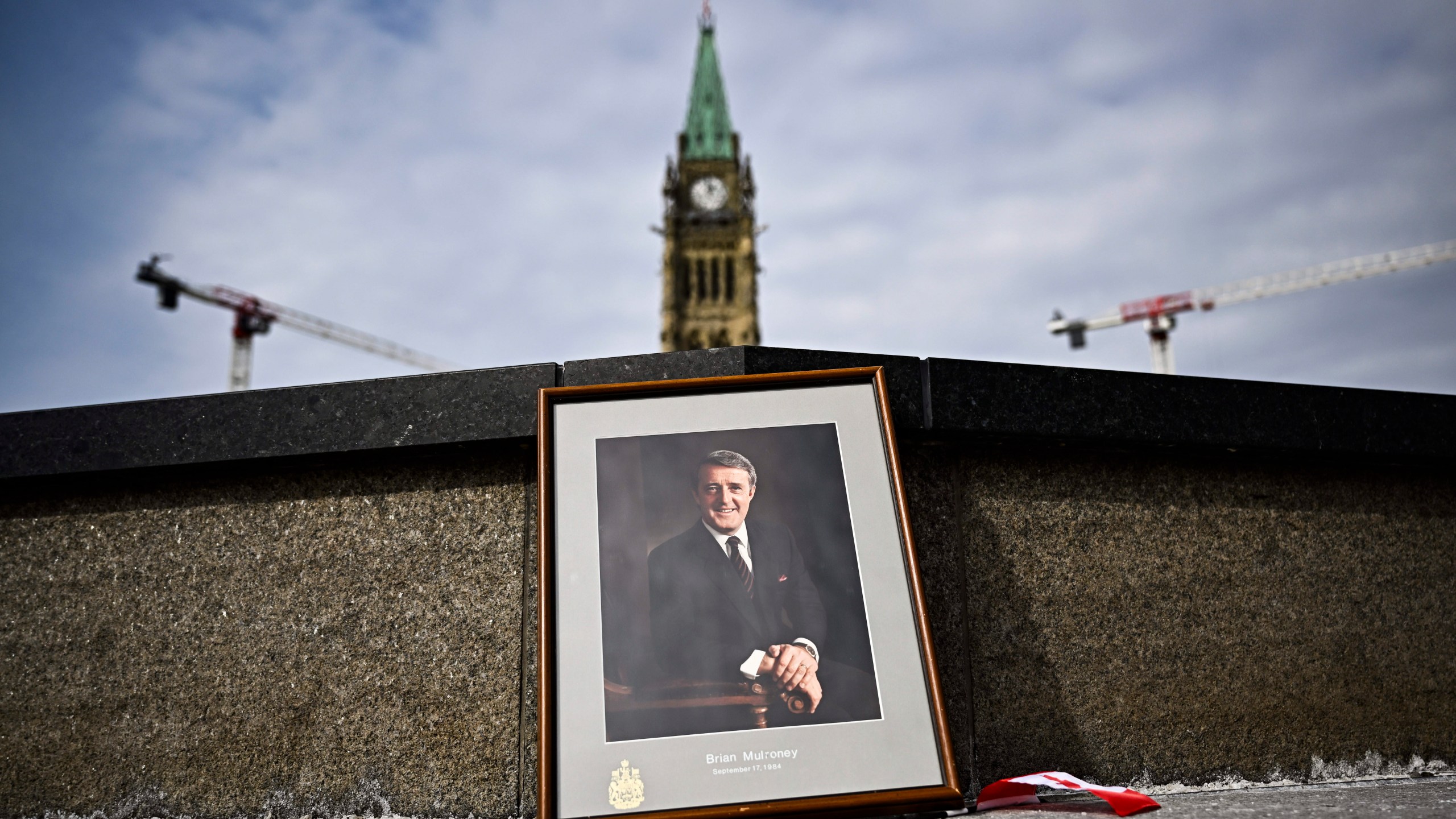 A framed portrait of former Canadian Prime Minister Brian Mulroney leans against the Centennial Flame on Parliament Hill as Canadians mourn his death at the age of 84, in Ottawa, Ontario, Friday, March 1, 2024. A state funeral for Mulroney will be held on March 23 in Montreal, Prime Minister Justin Trudeau announced Tuesday, March 5. (Justin Tang/The Canadian Press via AP, File)
