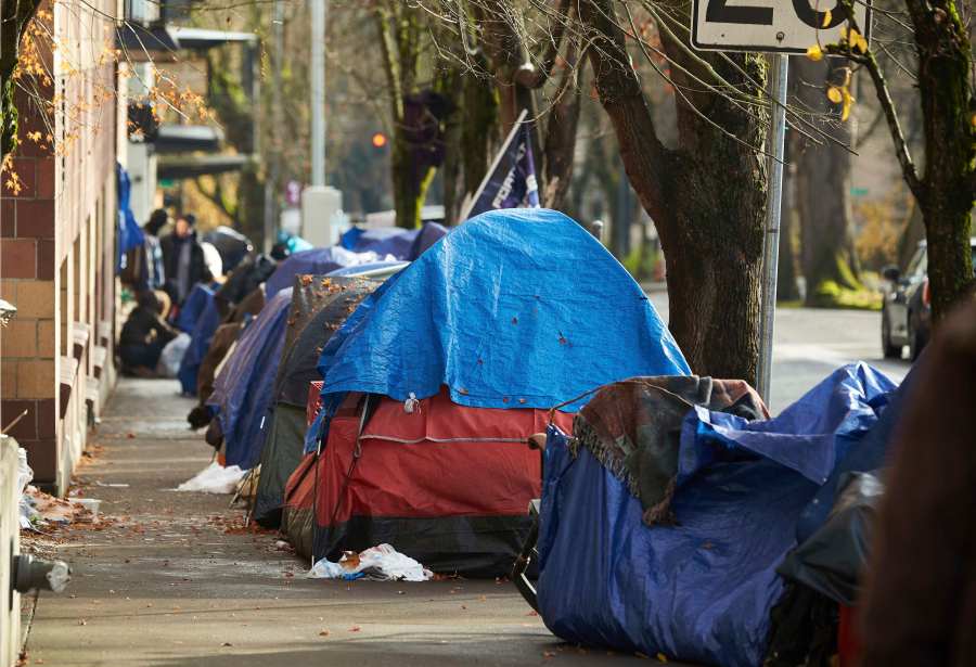 FILE - Tents line the sidewalk on Clay Street, Dec. 9, 2020, in Portland, Ore. Momentum is building in a case regarding homeless encampments before the U.S. Supreme Court that could have major implications for cities as homelessness nationwide has reached record highs. (AP Photo/Craig Mitchelldyer, File)