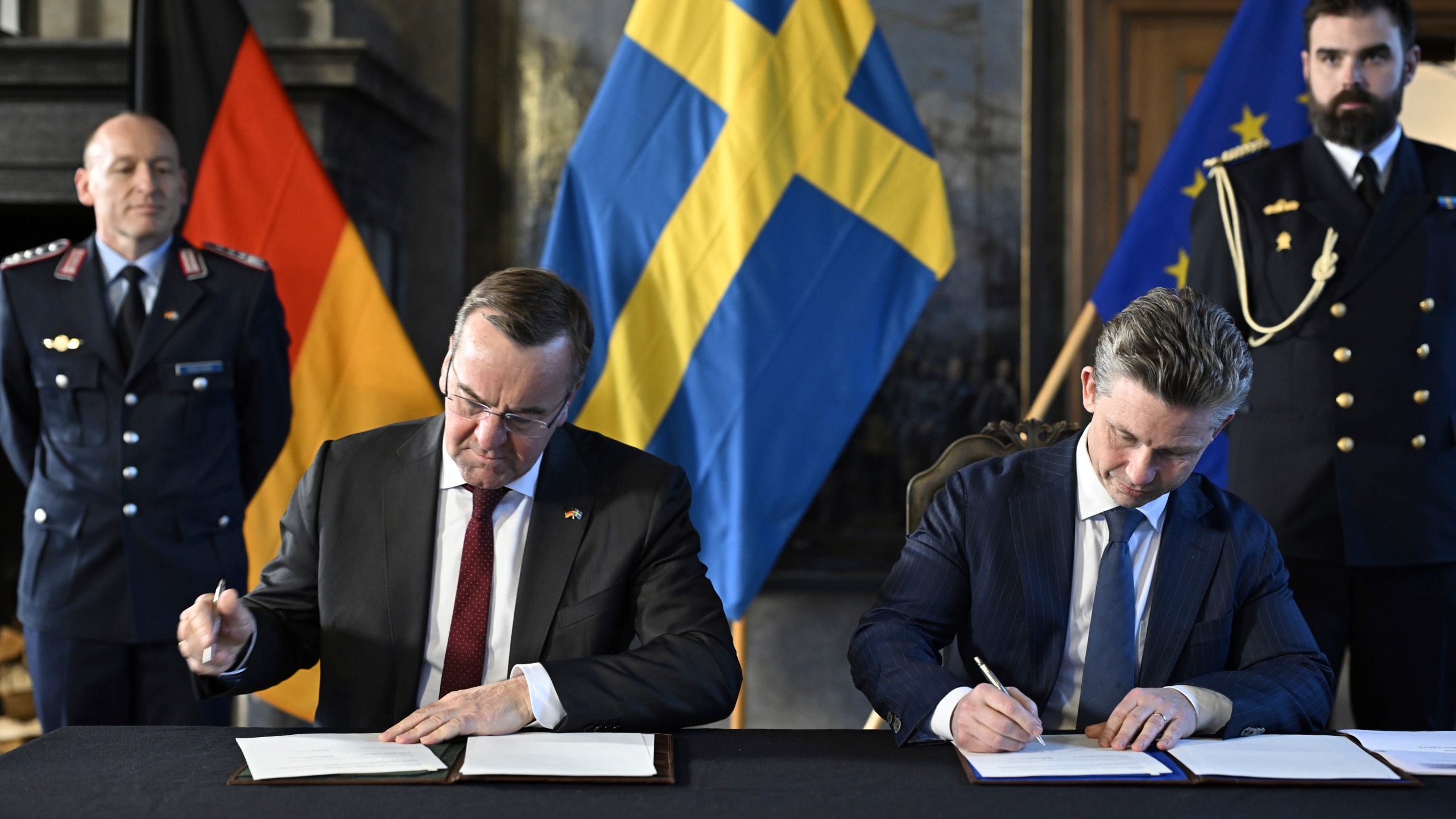 German Defense Minister Boris Pistorius, centre left, and Swedish Defense Minister Pål Jonson sign a letter of intent during their meeting at Karlberg Palace in Solna, Stockholm, Tuesday, March 5, 2024. (Pontus Lundahl/TT News Agency via AP)