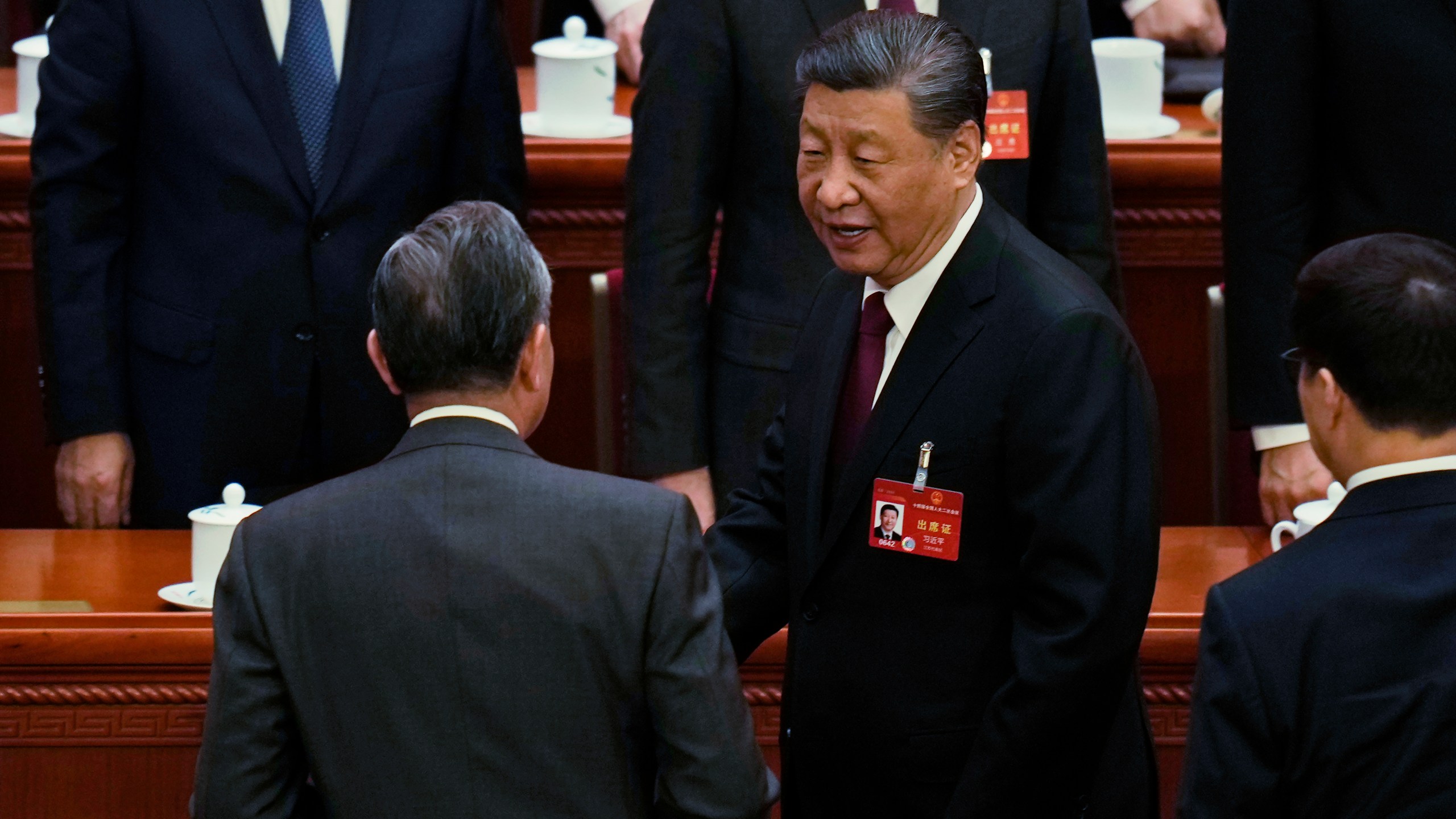 Chinese President Xi Jinping, right, chats with Foreign Minister Wang Yi as he leaves after the opening session of the National People's Congress (NPC) at the Great Hall of the People in Beijing, China, Tuesday, March 5, 2024. (AP Photo/Ng Han Guan)