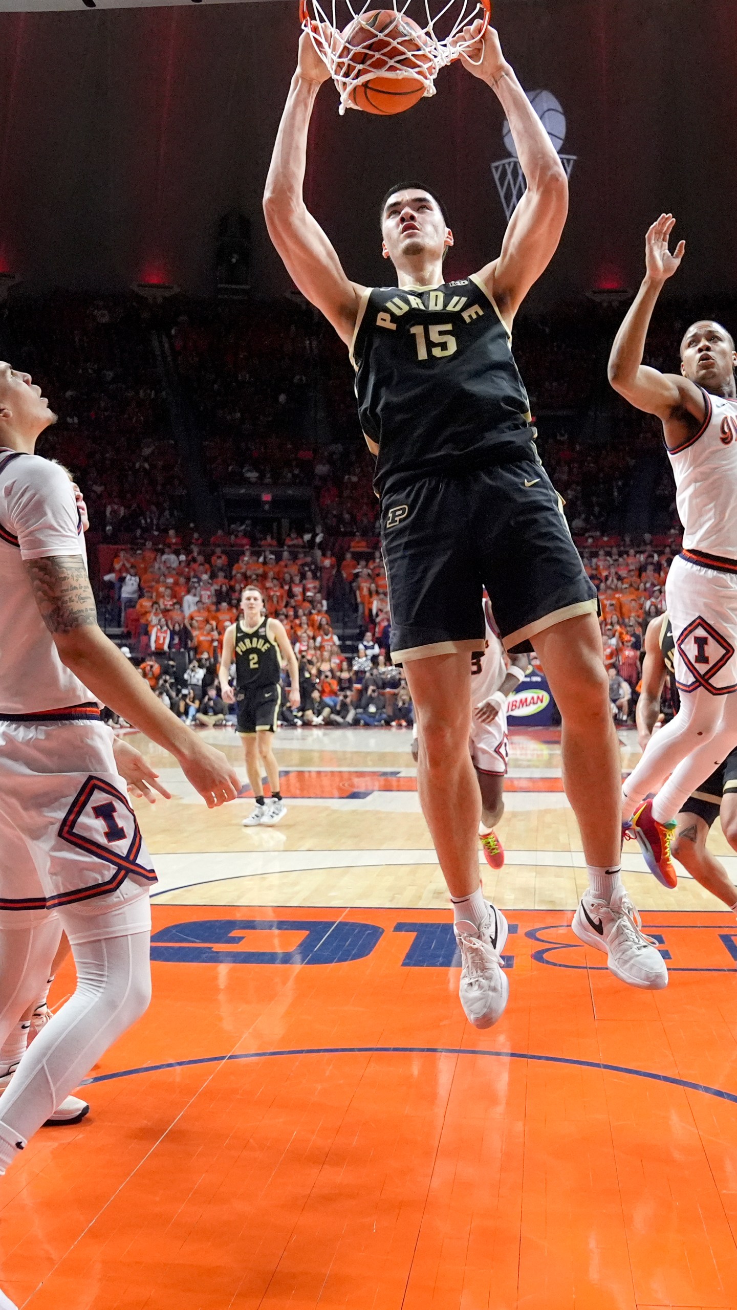 Purdue's Zach Edey (15) dunks between Illinois' Coleman Hawkins (33) and Justin Harmon during the first half of an NCAA college basketball game Tuesday, March 5, 2024, in Champaign, Ill. (AP Photo/Charles Rex Arbogast)