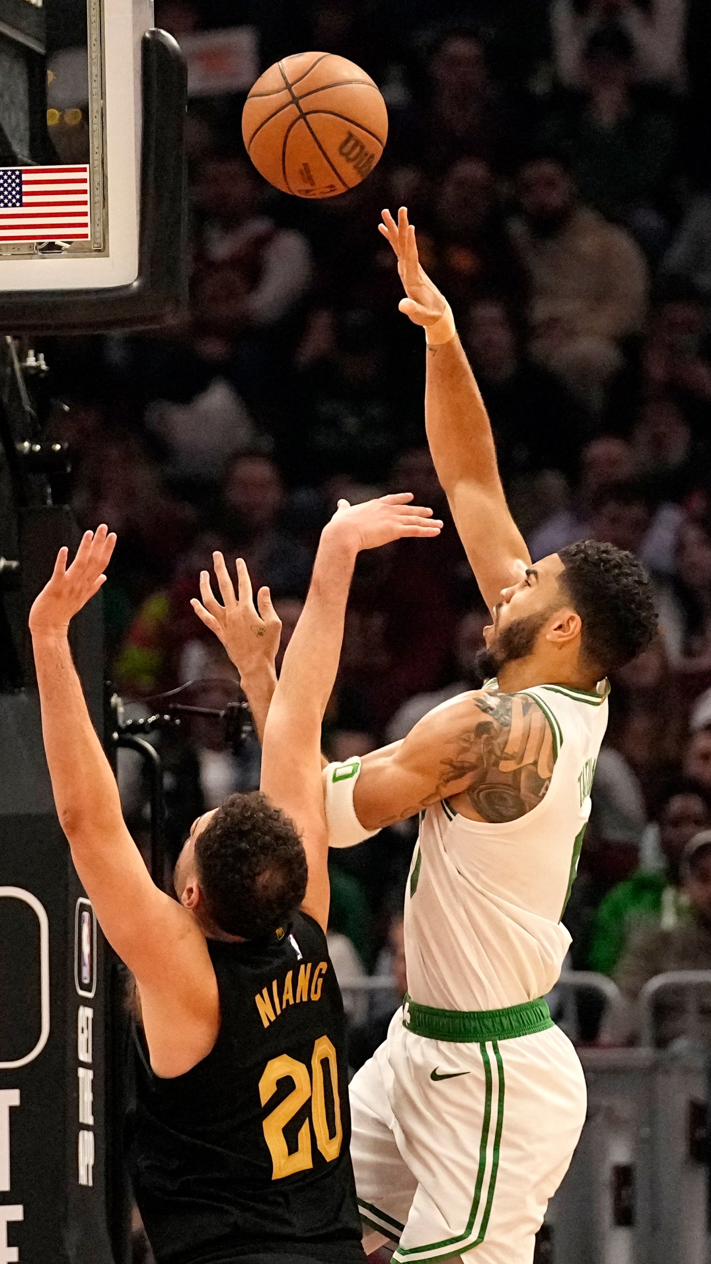 Boston Celtics forward Jayson Tatum, right, shoots in front of Cleveland Cavaliers forward Georges Niang (20) in the first half of an NBA basketball game, Tuesday, March 5, 2024, in Cleveland. (AP Photo/Sue Ogrocki)