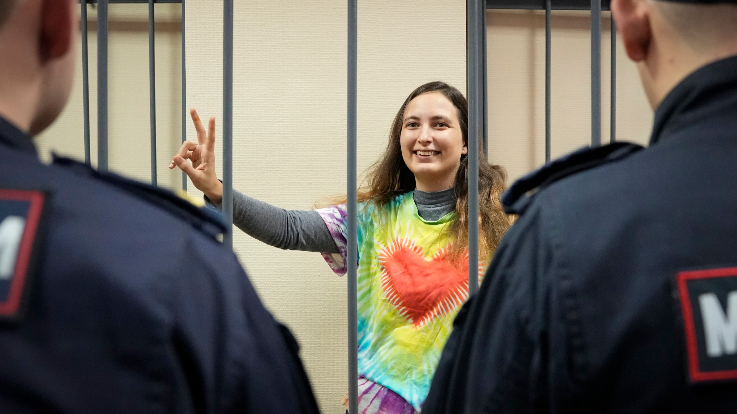 FILE - Sasha Skochilenko, a 33-year-old artist and musician, makes a victory sign standing behind bars in court in St. Petersburg, Russia, Thursday, Nov. 16, 2023, for protesting the conflict in Ukraine. Over the last decade, Vladimir Putin's Russia evolved from a country that tolerates at least some dissent to one that ruthlessly suppresses it. Arrests, trials and long prison terms — once rare — are commonplace. (AP Photo, File)