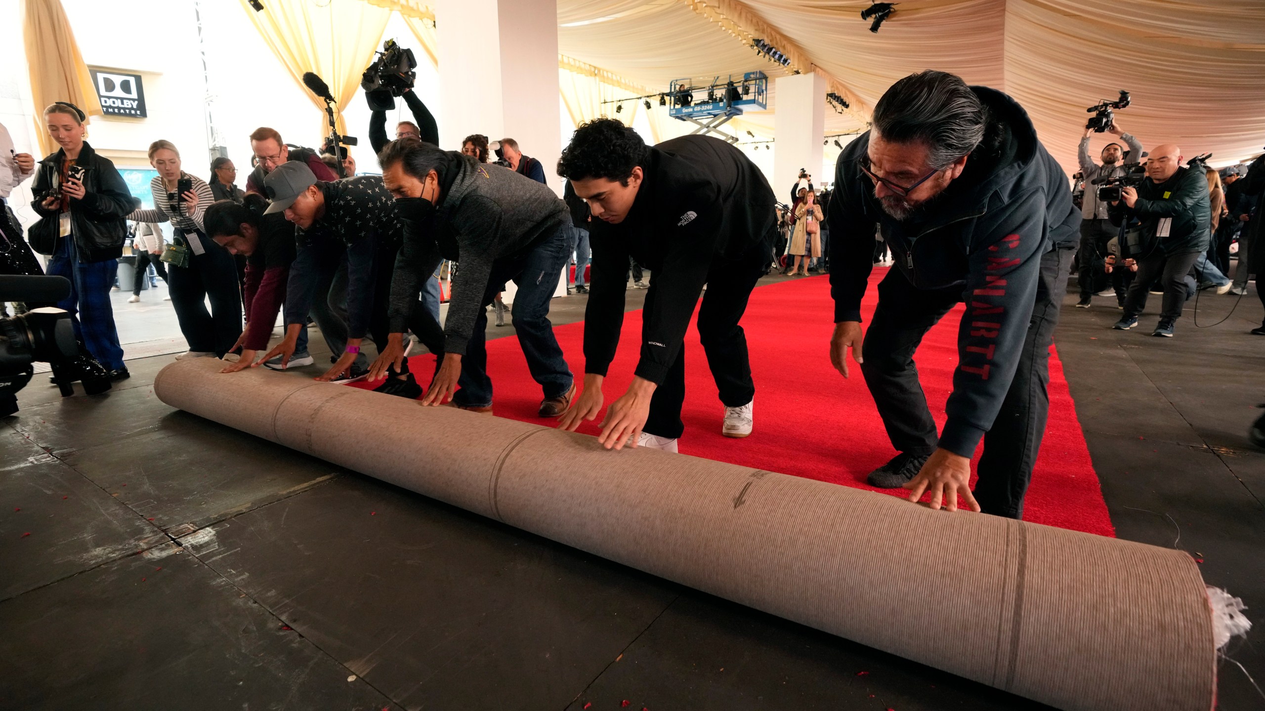 Crew members roll out the red carpet for Sunday's 96th Academy Awards at the Dolby Theatre, Wednesday, March 6, 2024, in Los Angeles. (AP Photo/Chris Pizzello)