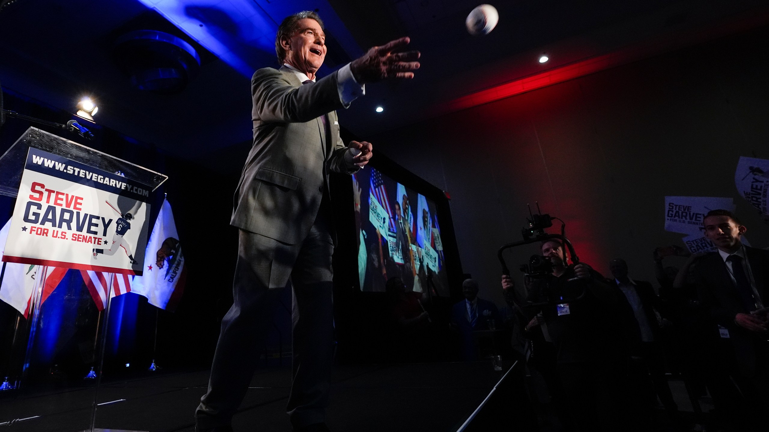 Republican U.S. Senate candidate Steve Garvey tosses a baseball to supporters during his election night party, Tuesday, March 5, 2024, in Palm Desert, Calif. (AP Photo/Gregory Bull)