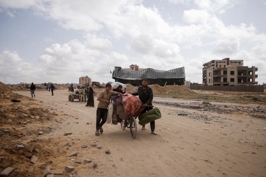 Palestinians carry their belonging after visiting their houses destroyed in the Israeli offensive on Khan Younis, Gaza Strip, Wednesday, March 6, 2024. (AP Photo/Mohammed Dahman)